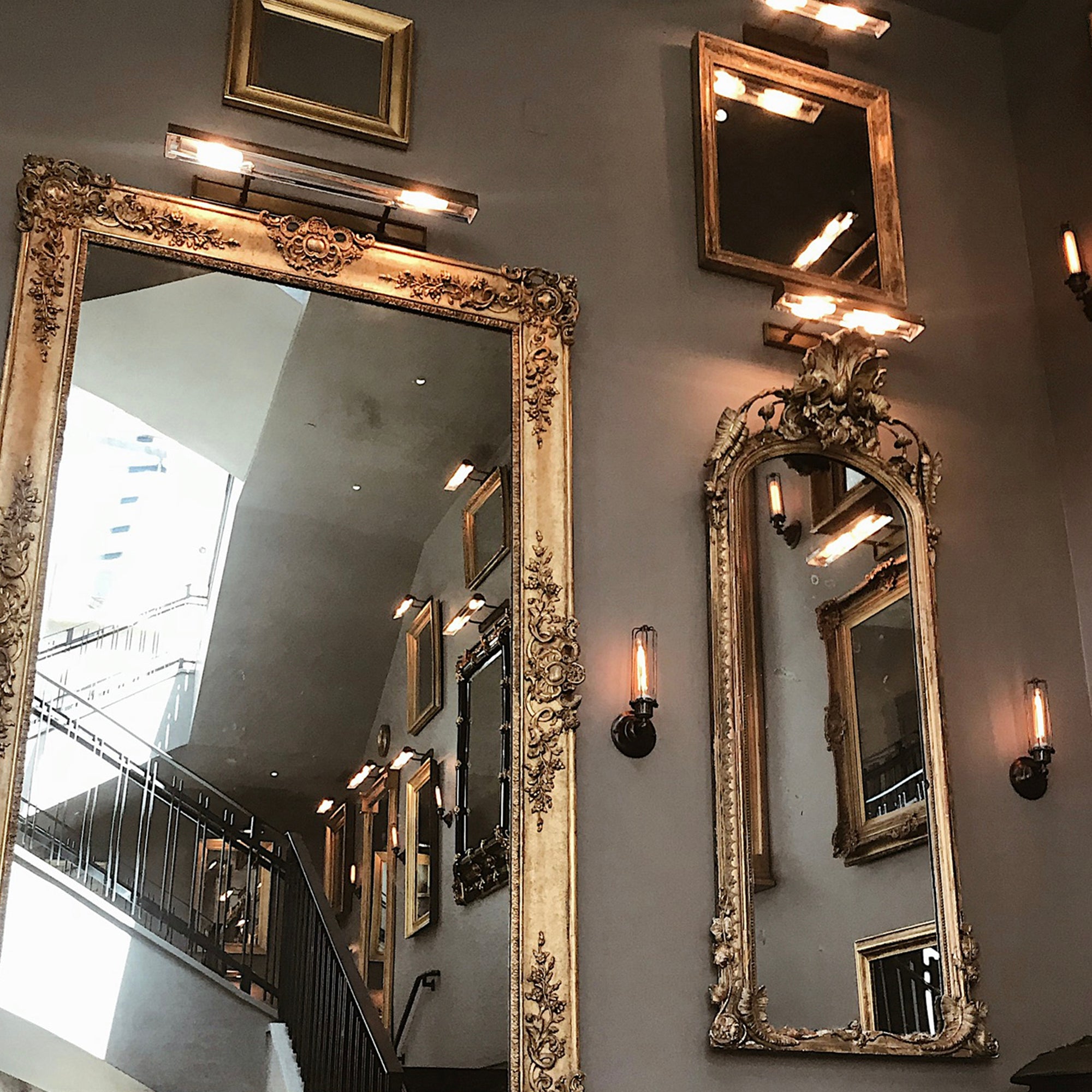 Restoration Hardware West Hollywood showroom featuring ornate gilded mirrors and warm lighting.