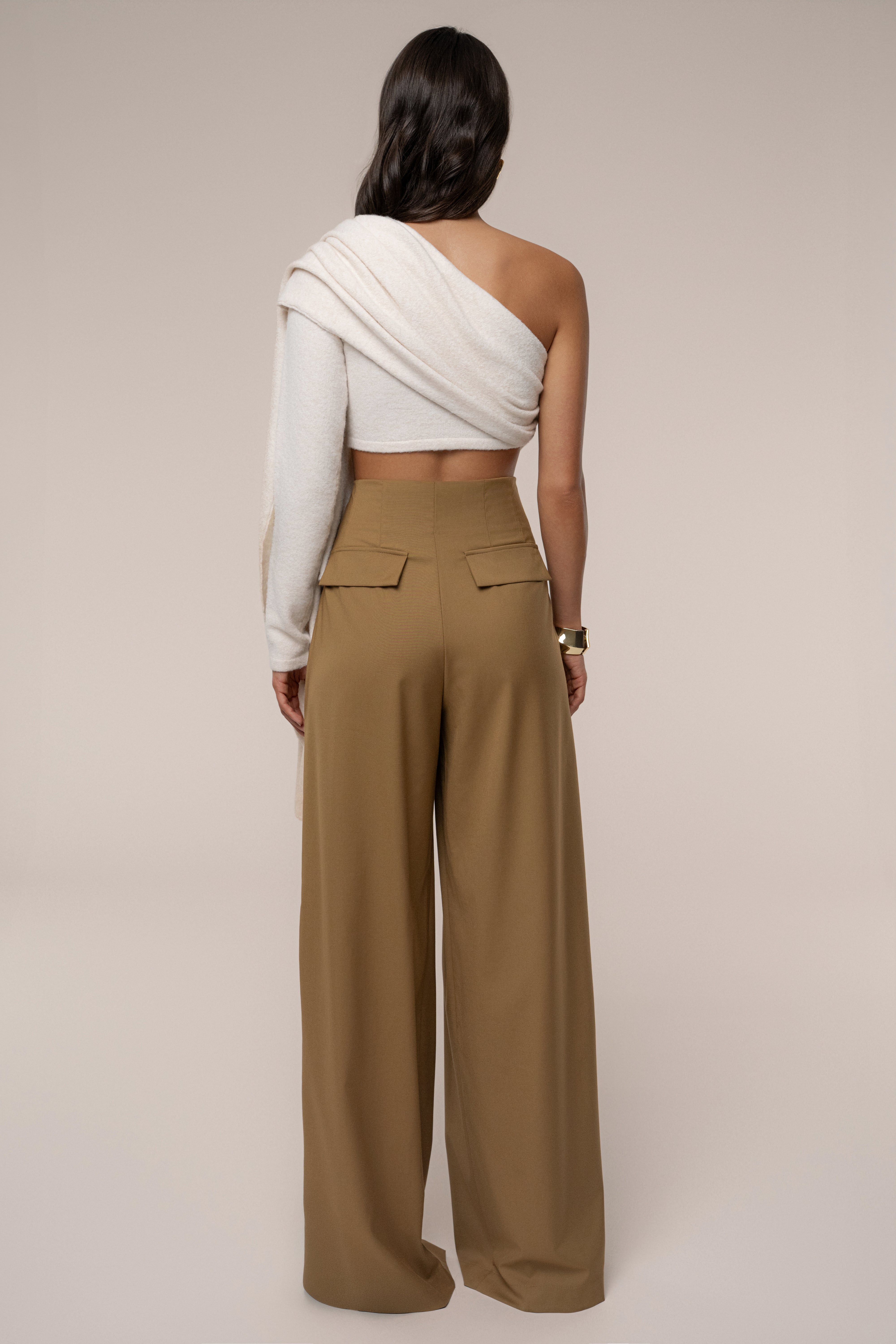 Ivory capsule one-shoulder top by JLUXLABEL displayed on a hanger, showcasing its elegant design and smooth fabric.
