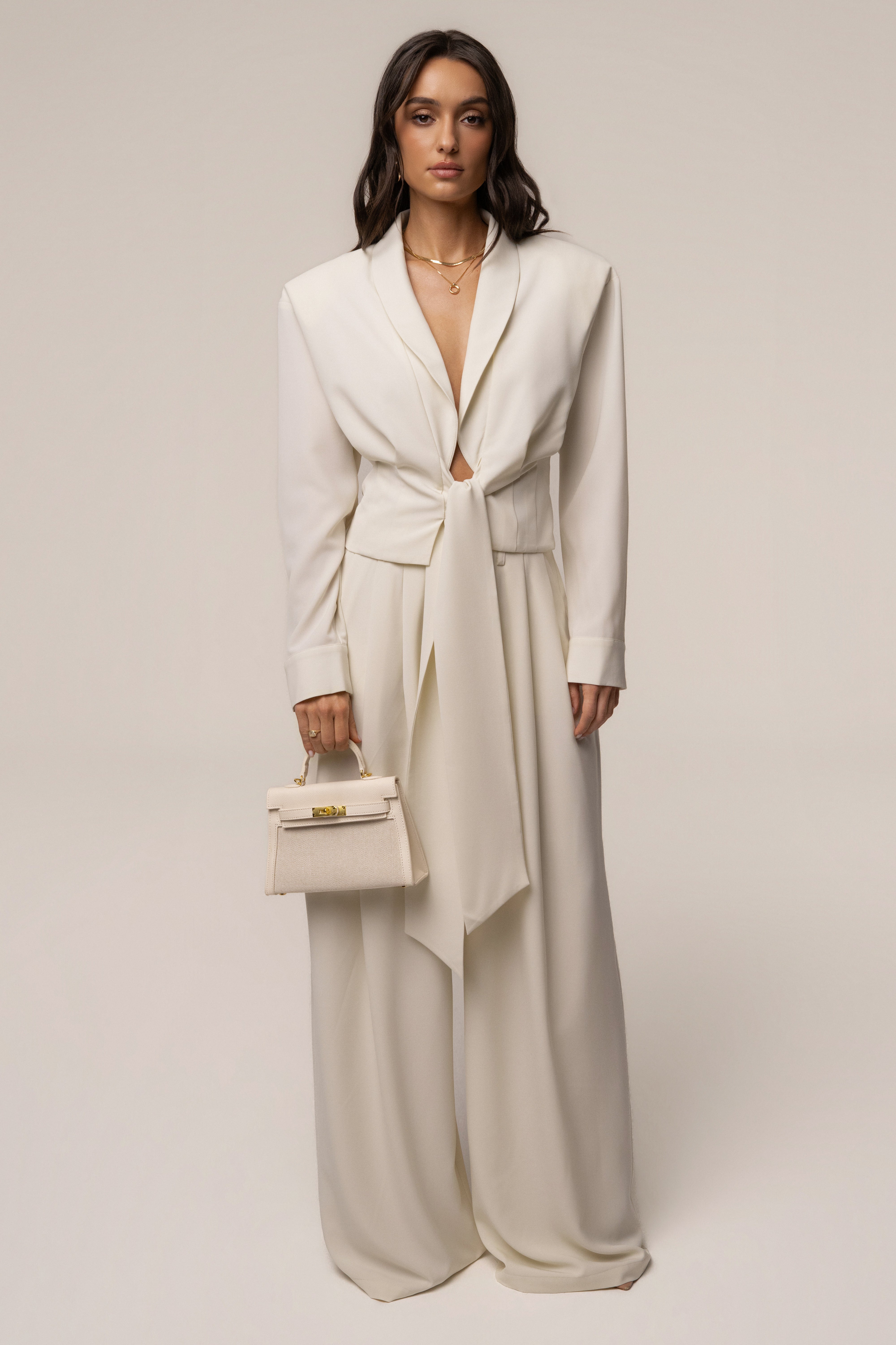 Cream JLUXLABEL estate wrap top with long sleeves and V-neck, styled on a model showcasing its flattering fit and elegant design.