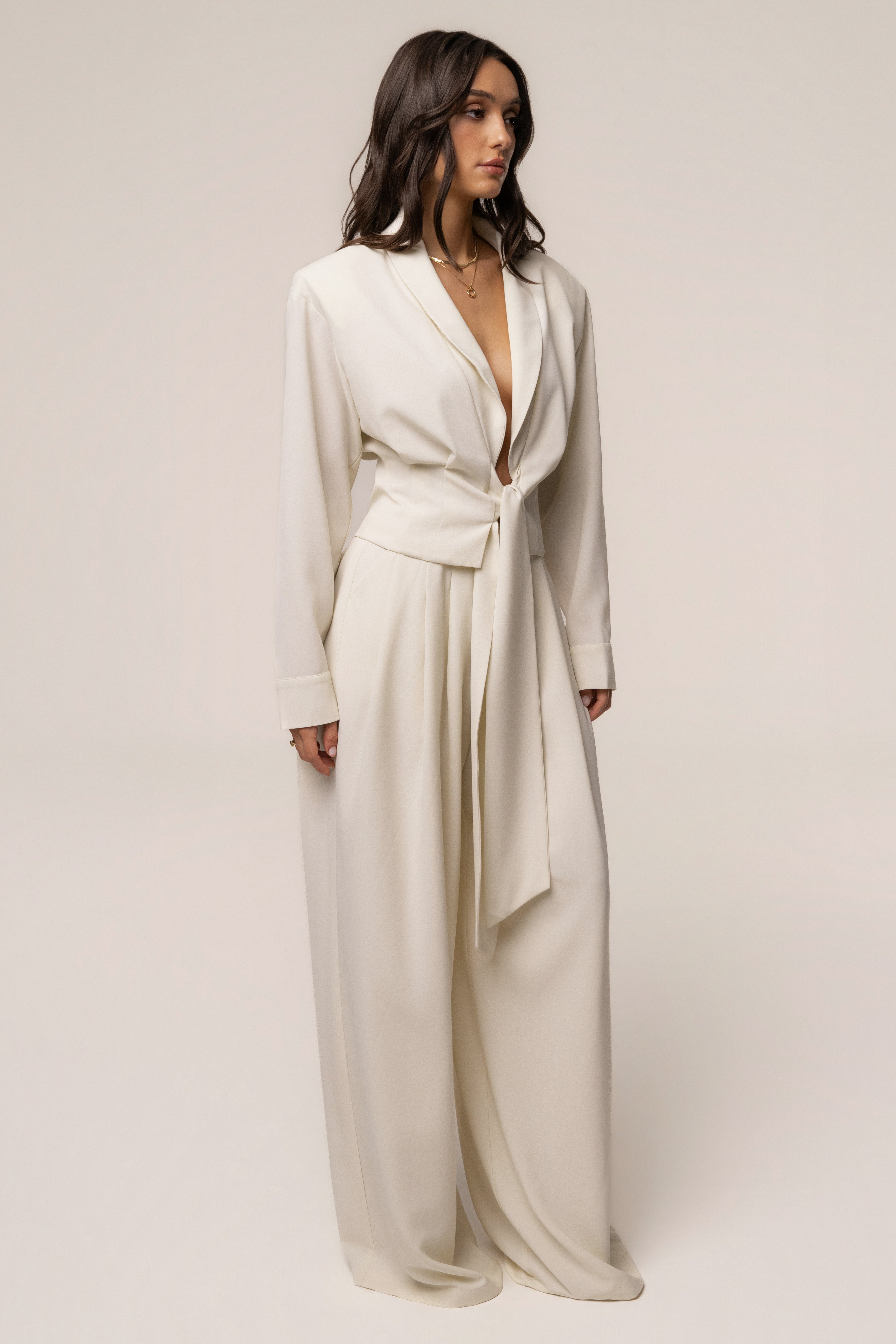 Cream estate pleated trousers by JLUXLABEL, showcasing the elegant high-waisted design and tailored pleats in a stylish bottom.
