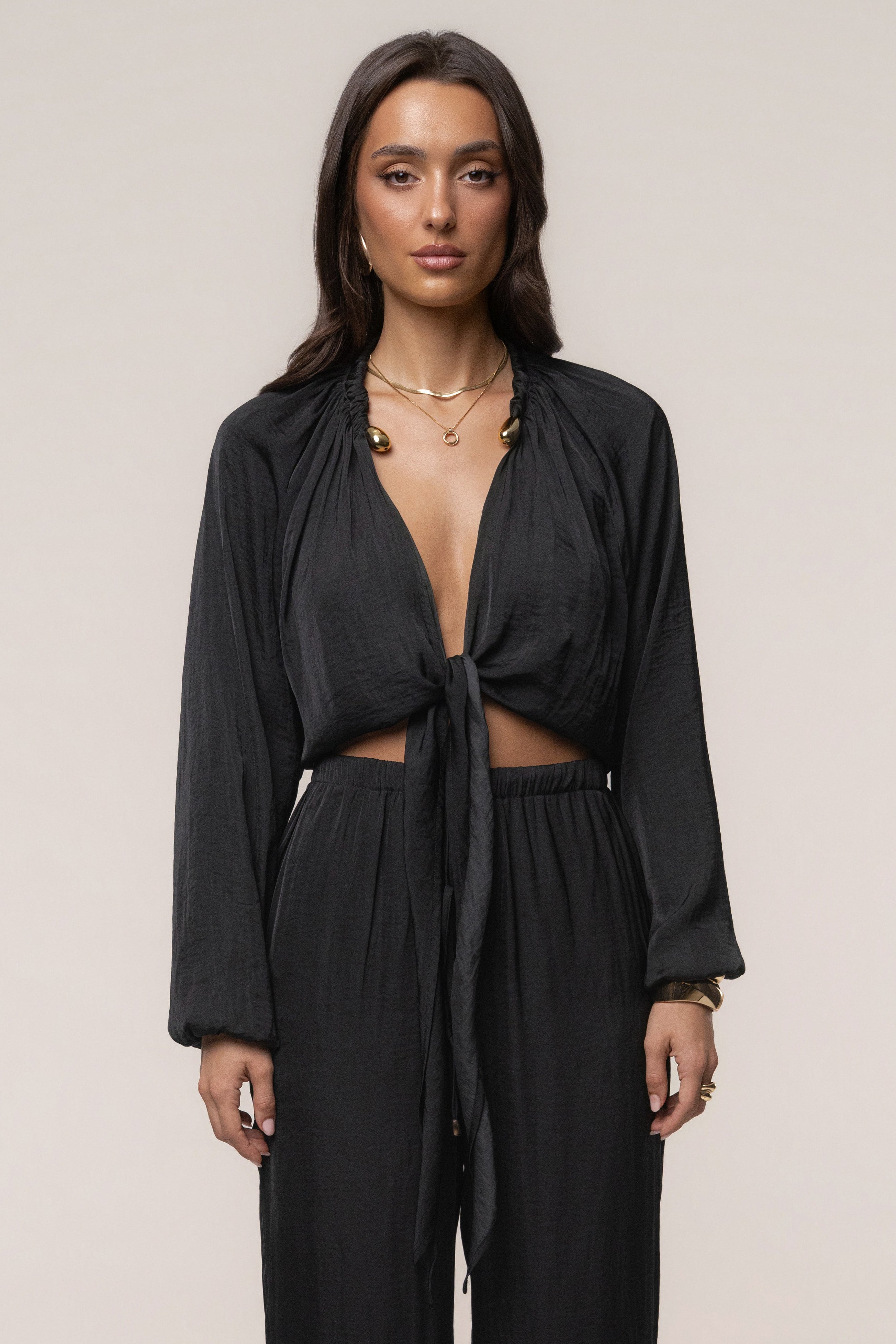 Black Seaside Glow Top by JLUXLABEL featuring a fitted design and stylish neckline, displayed on a model.