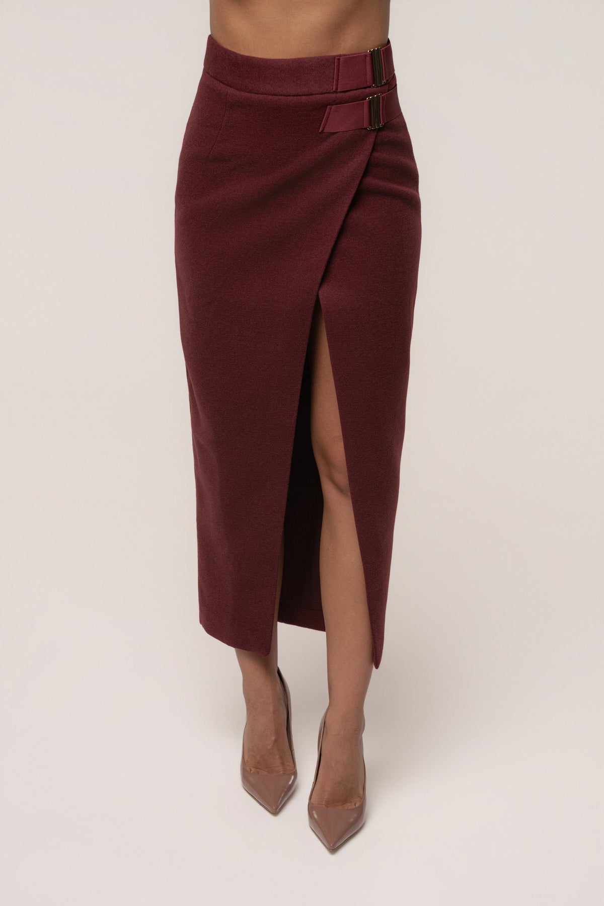 Burgundy Gisele slit skirt by JLUXLABEL, showing a stylish midi skirt with a slit detail and smooth fabric, worn by a model.