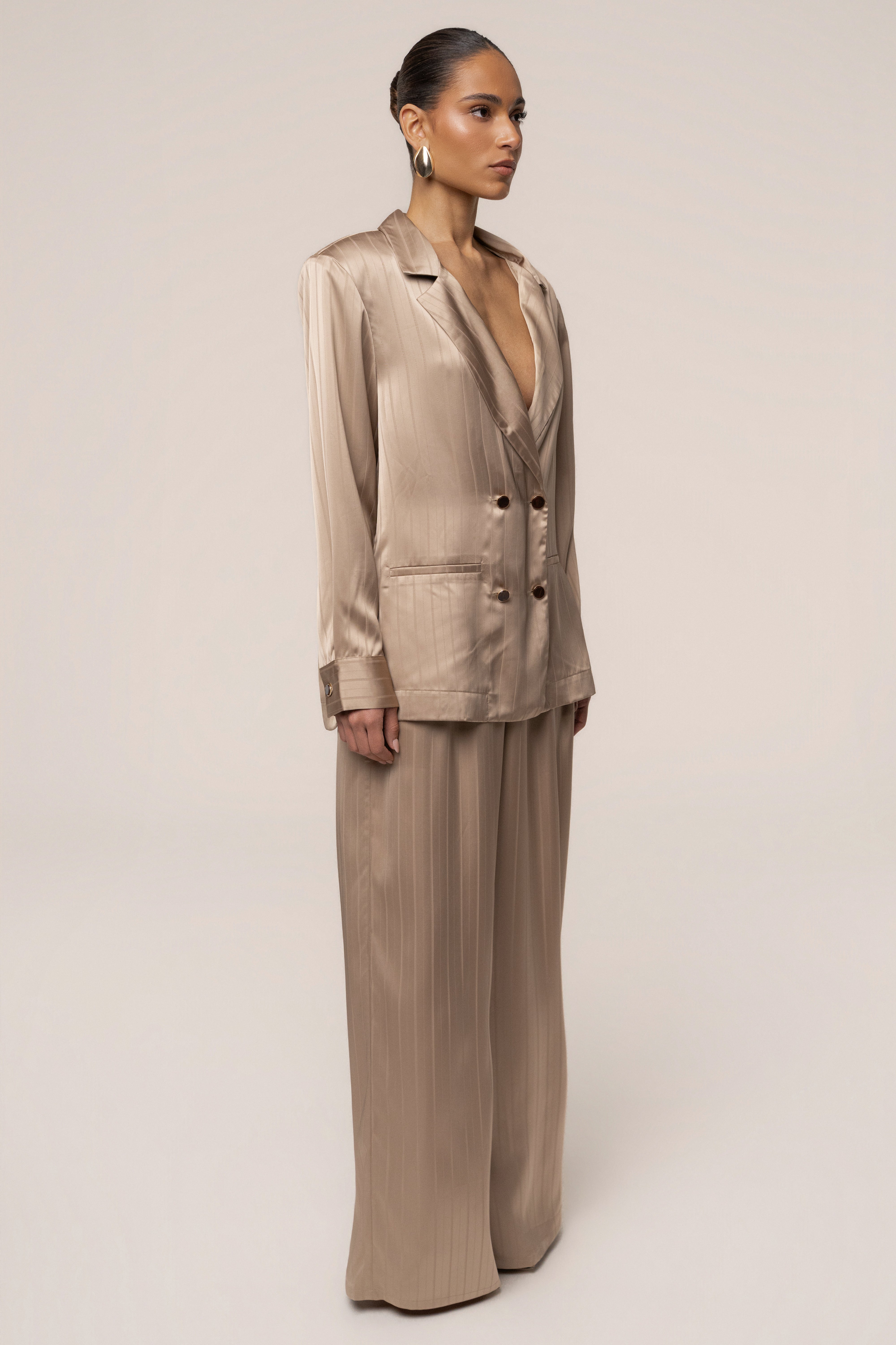 JLUXLABEL Stone The Standard blazer, a stylish tailored top in neutral stone color, displayed on a hanger.