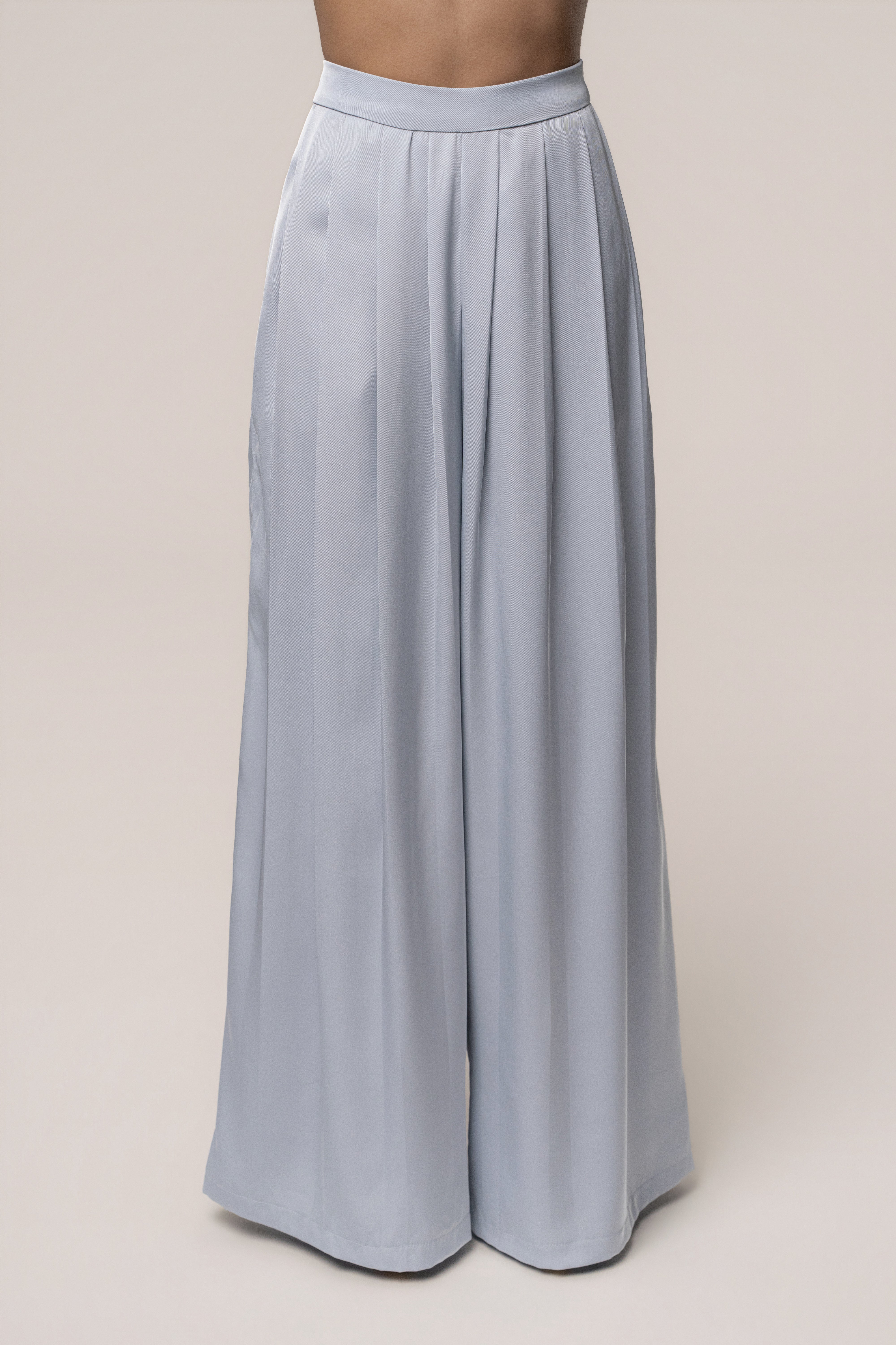 Blue Clara wide-leg pleated trousers from JLUXLABEL, showing the flowing fabric and high waist design.