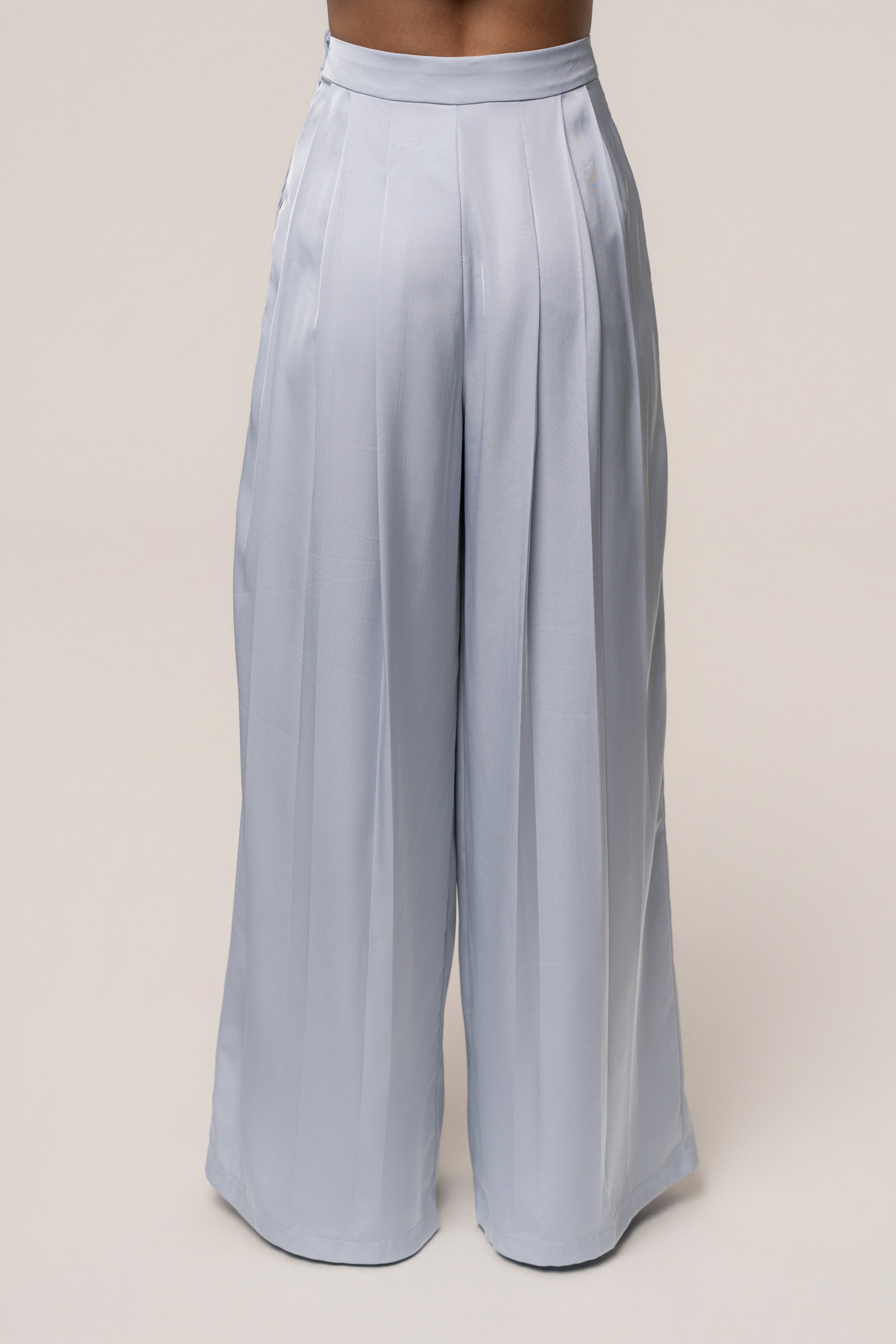 Blue Clara wide-leg pleated trousers from JLUXLABEL, featuring a relaxed fit and elegant pleats, styled as casual or office bottoms.