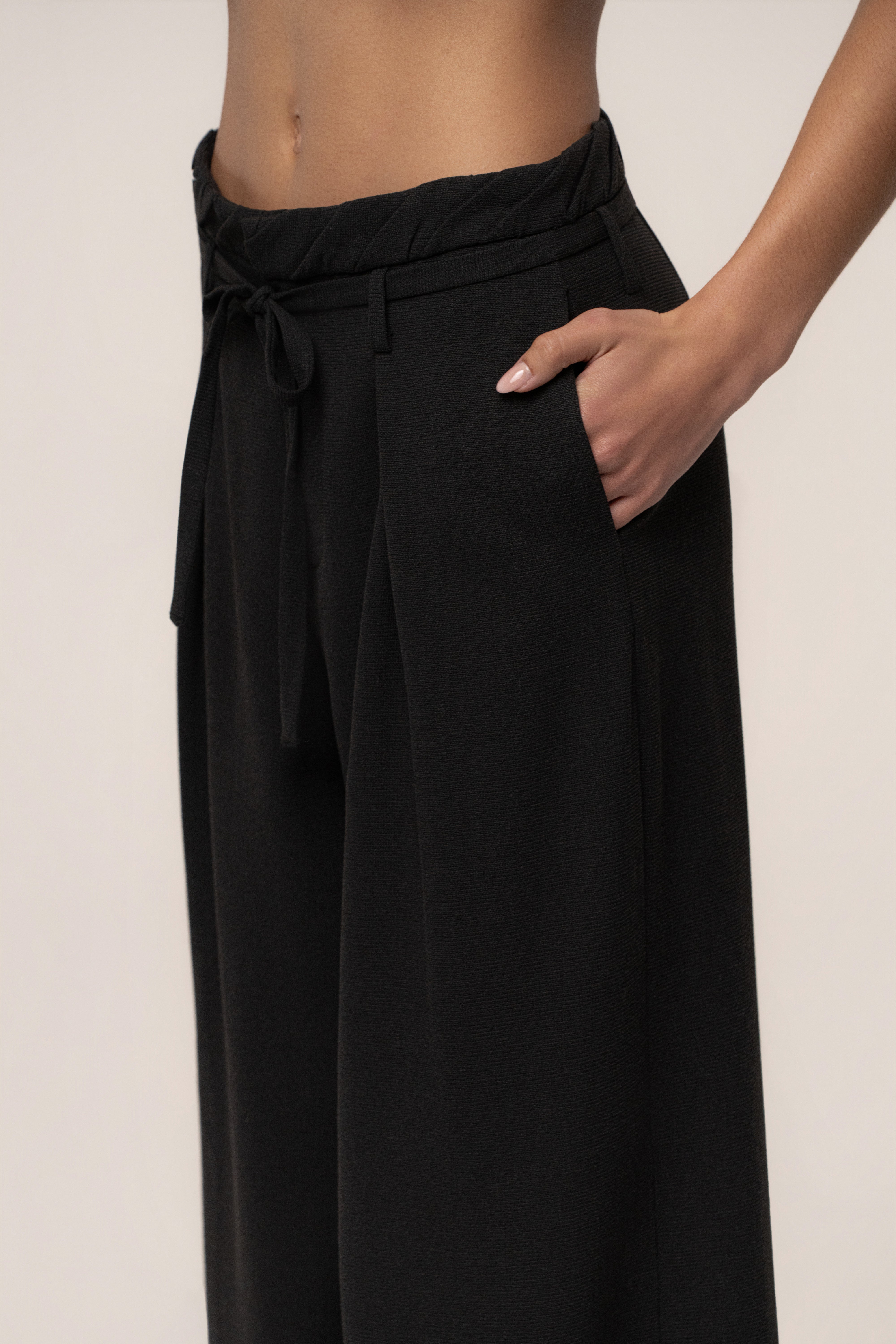 Black refined wide-leg pants by JLUXLABEL, stylish bottoms with a smooth fit and wide-leg design, shown on a model.