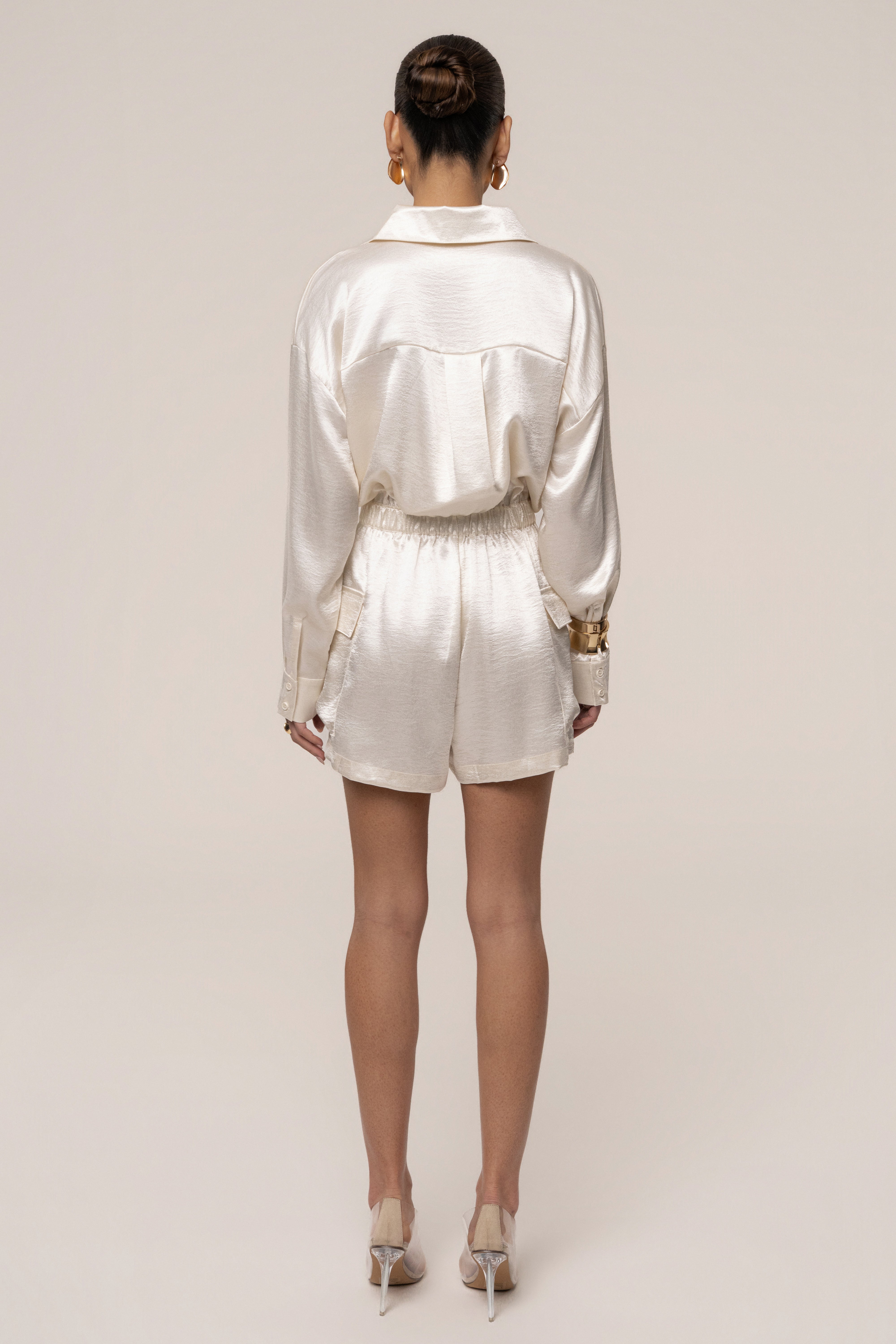 Ivory City Shine Metallic Romper by JLUXLABEL featuring a sleek, shiny fabric and stylish jumpsuit design.