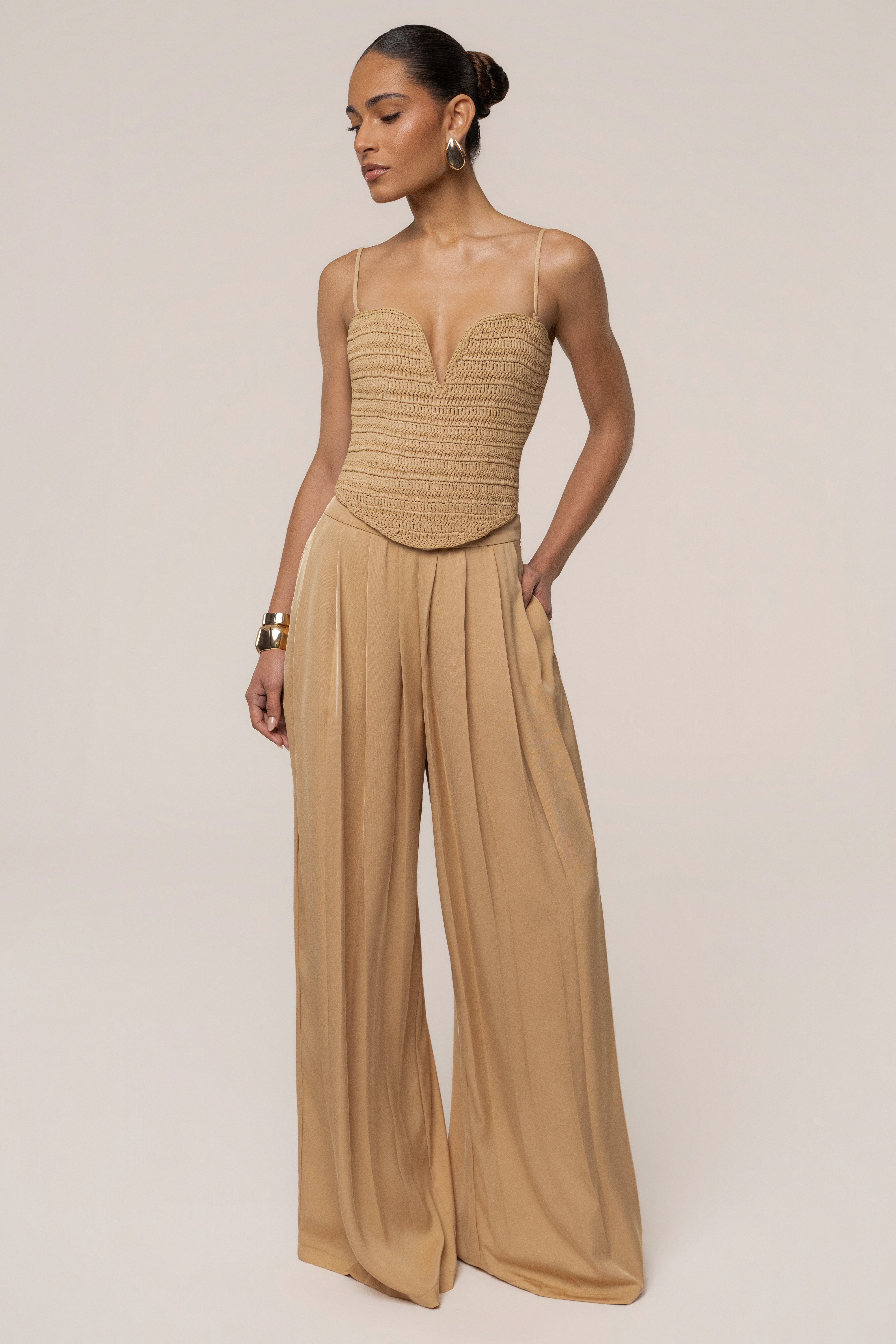 Beige JLUXLABEL Clara wide-leg pleated trousers shown from the front, featuring a high waist and flowing wide-leg design.