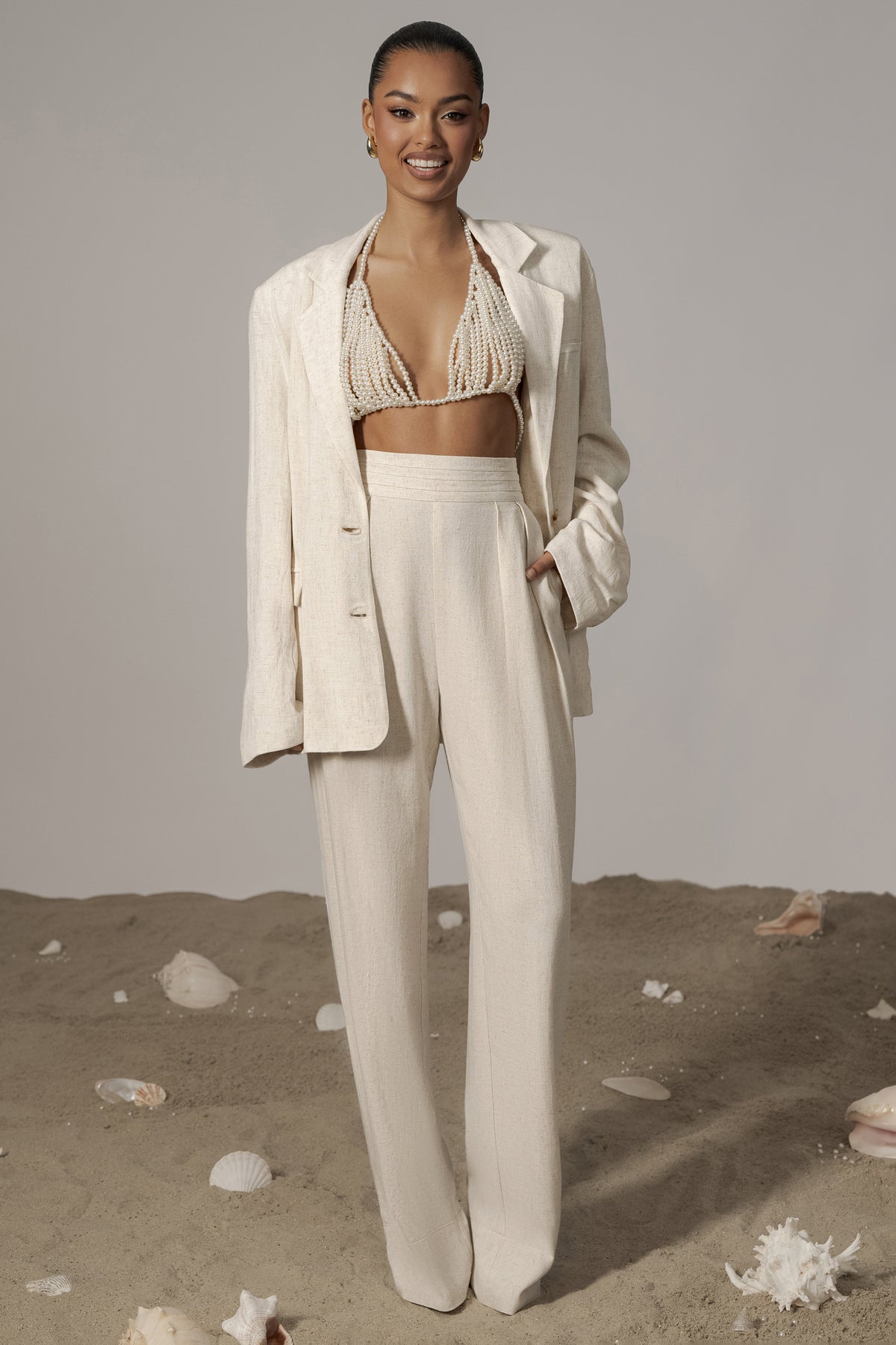 Natural Villa Views Linen Trousers by JLUXLABEL, beige bottoms with relaxed fit and wide-leg design, displayed on a model.