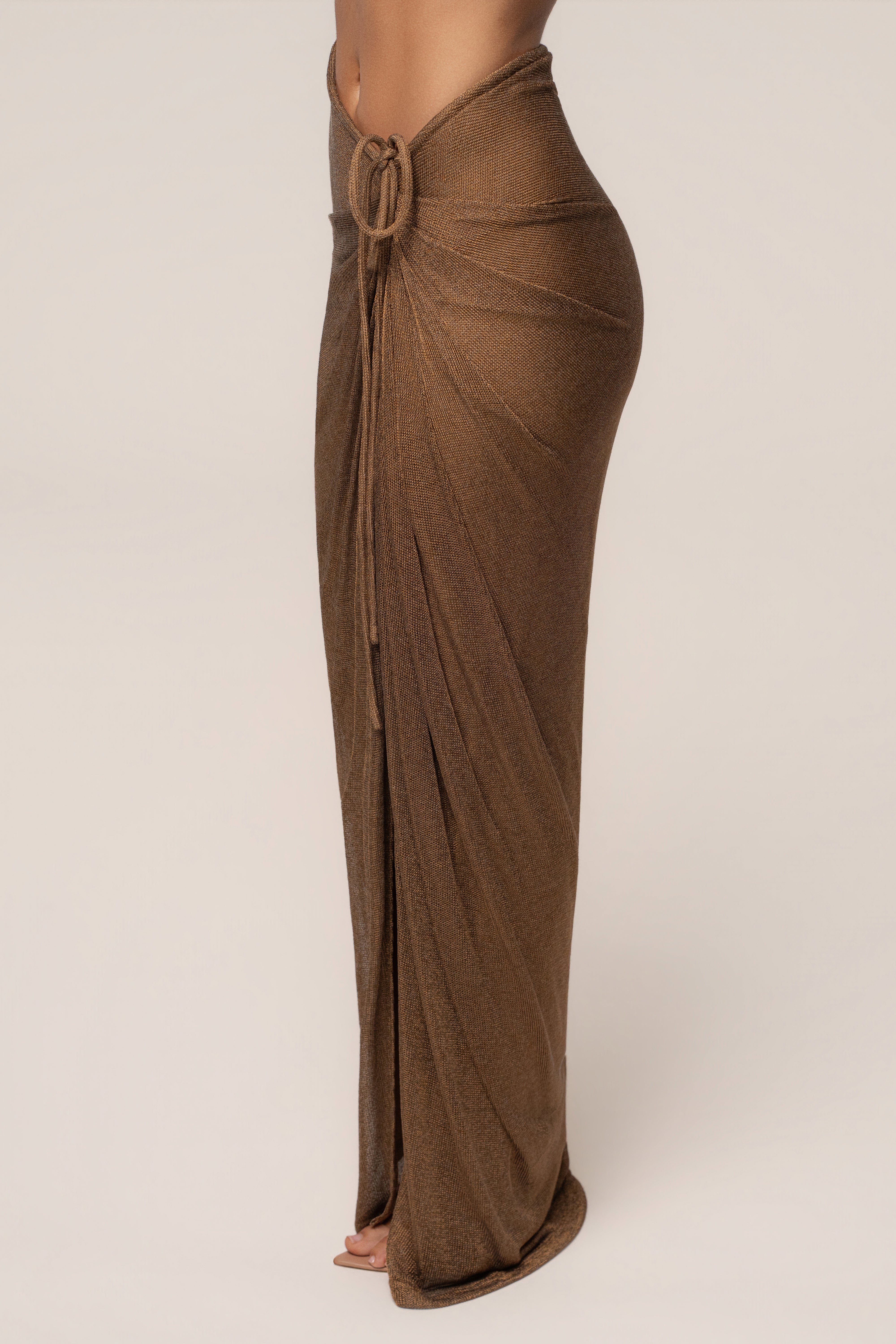 Bronze Noelia metallic slit skirt by JLUXLABEL, shown as a stylish women's bottoms piece with a shiny, metallic finish and slit detail.