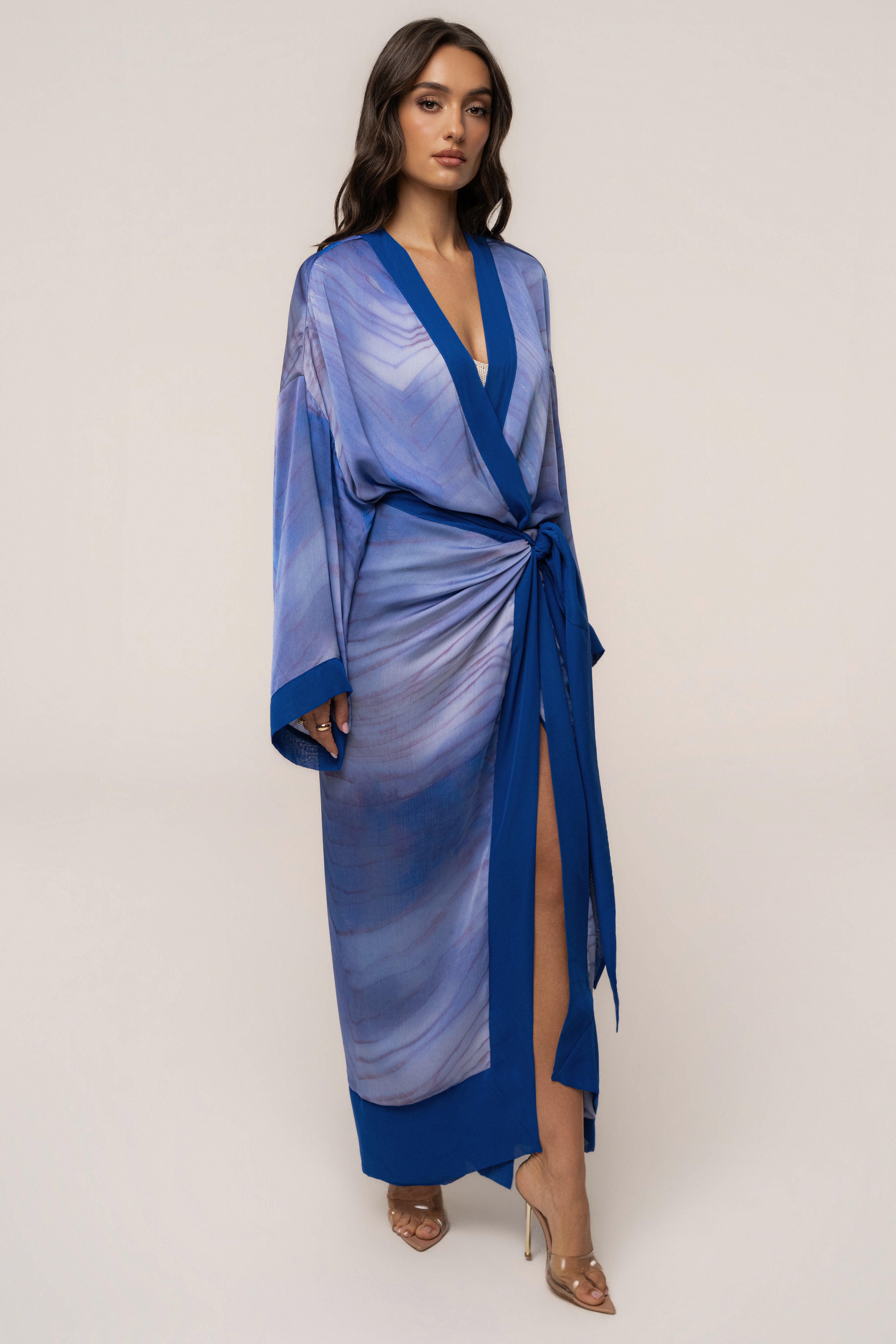 Blue Bahía satin duster outerwear by JLUXLABEL, shown hanging with a smooth, shiny satin fabric and flowing design.