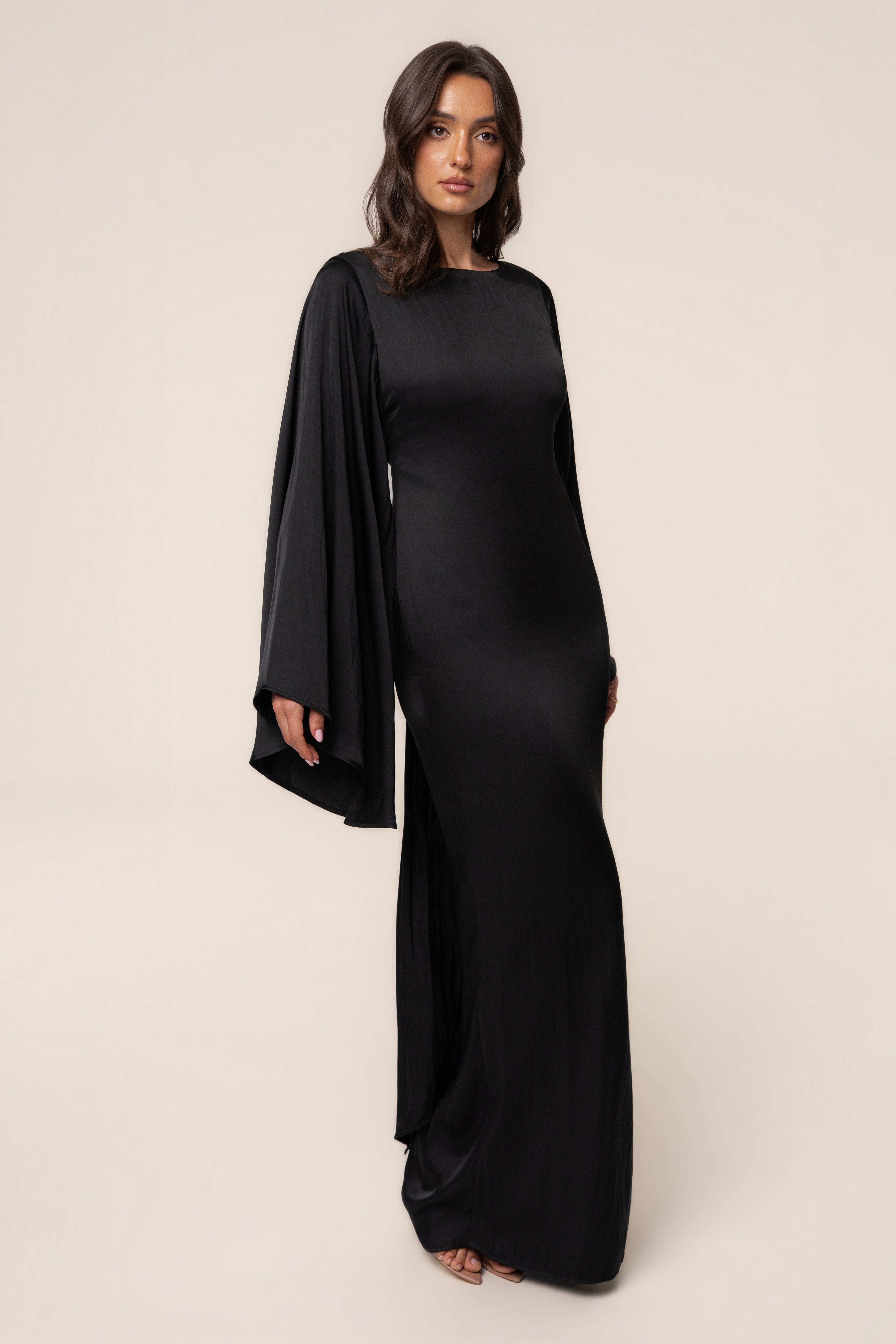 Black Soft Current Maxi Dress by JLUXLABEL, flowing fabric with a relaxed fit, displayed on a hanger against a neutral background.