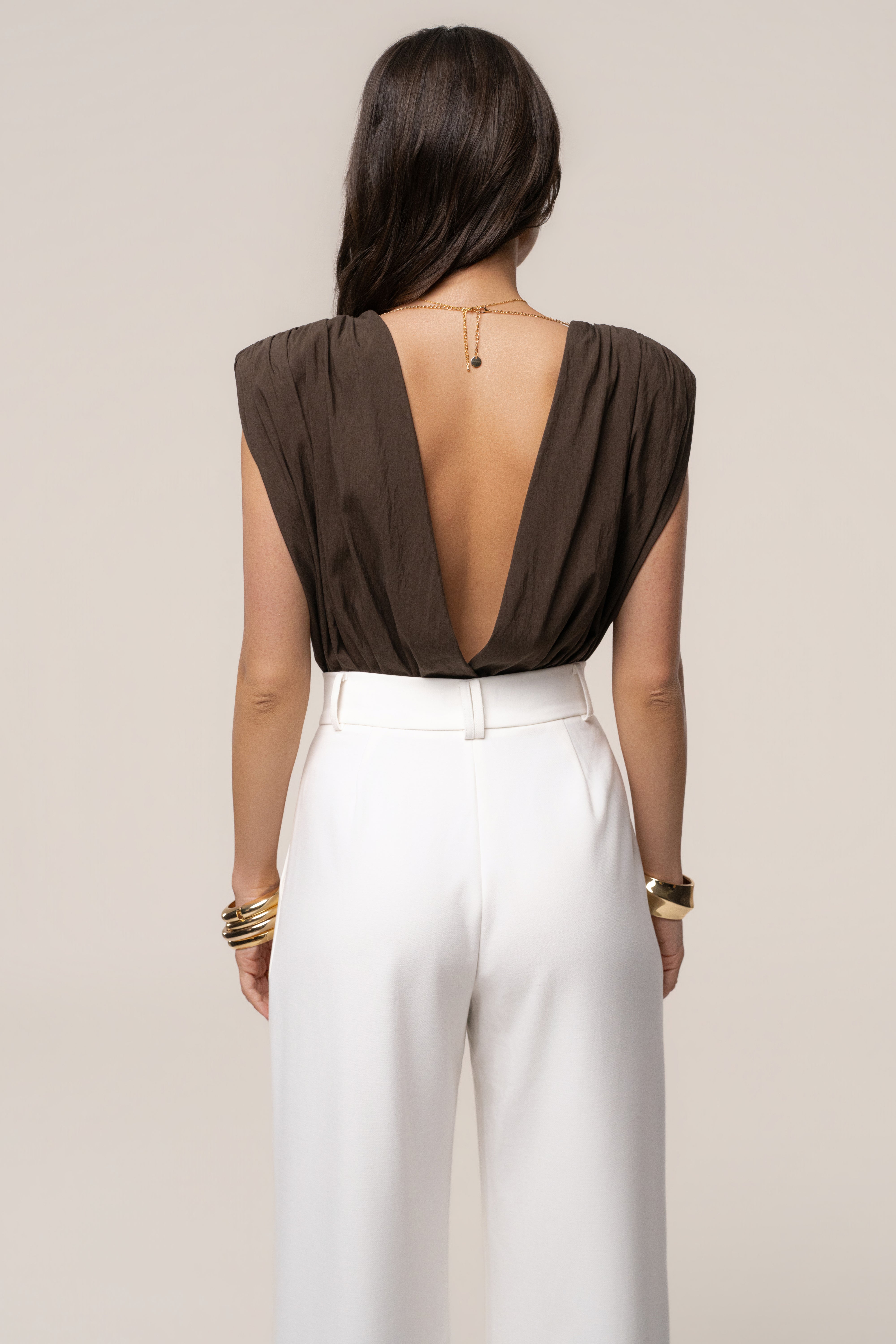 Brown Solar Drift Bodysuit by JLUXLABEL, featuring long sleeves and fitted style, shown on a model against a neutral background.