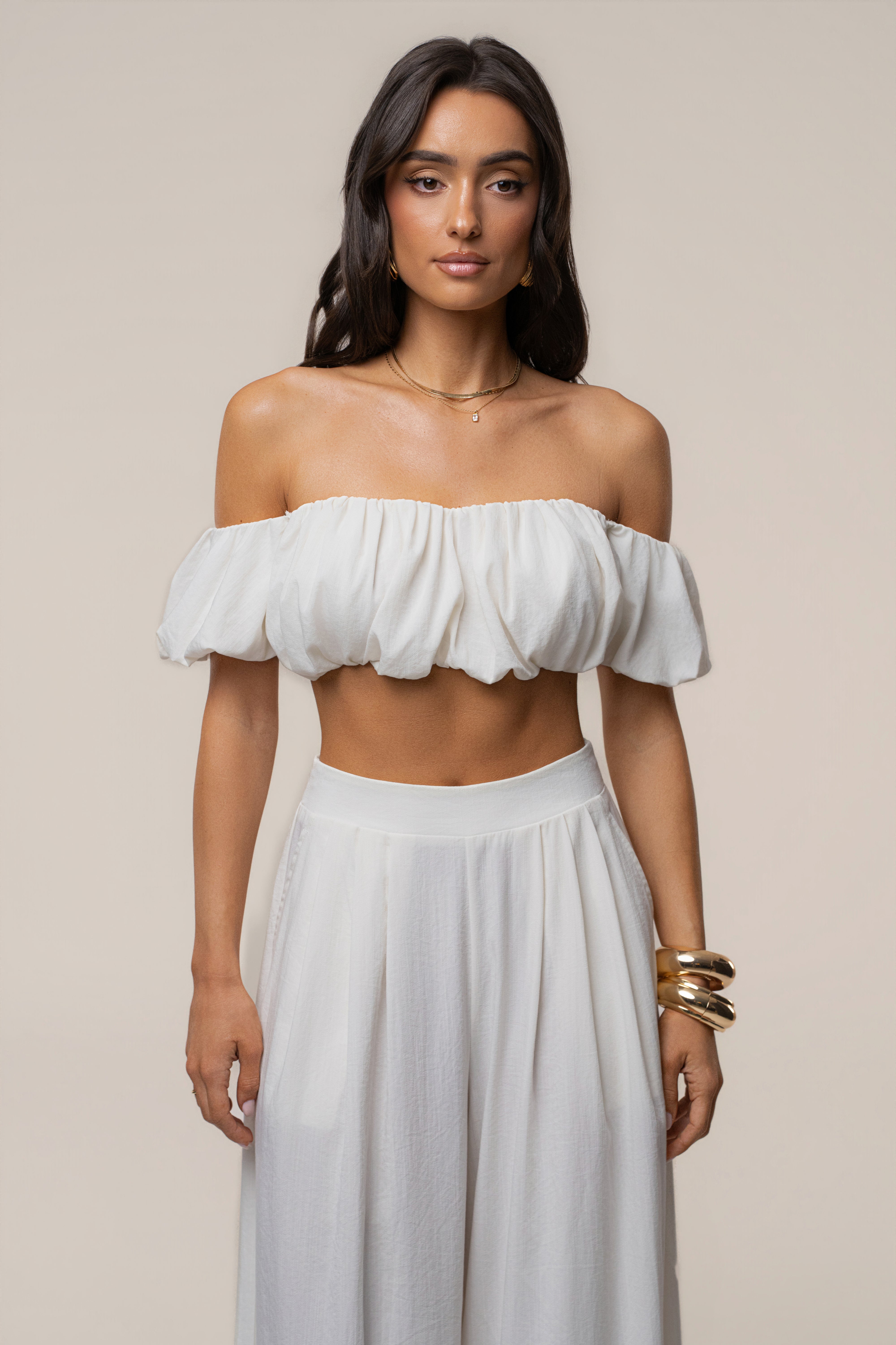 Model wearing ivory Sunset Breeze Pant Set with an off-shoulder ruffled crop top and matching wide-leg pants.
