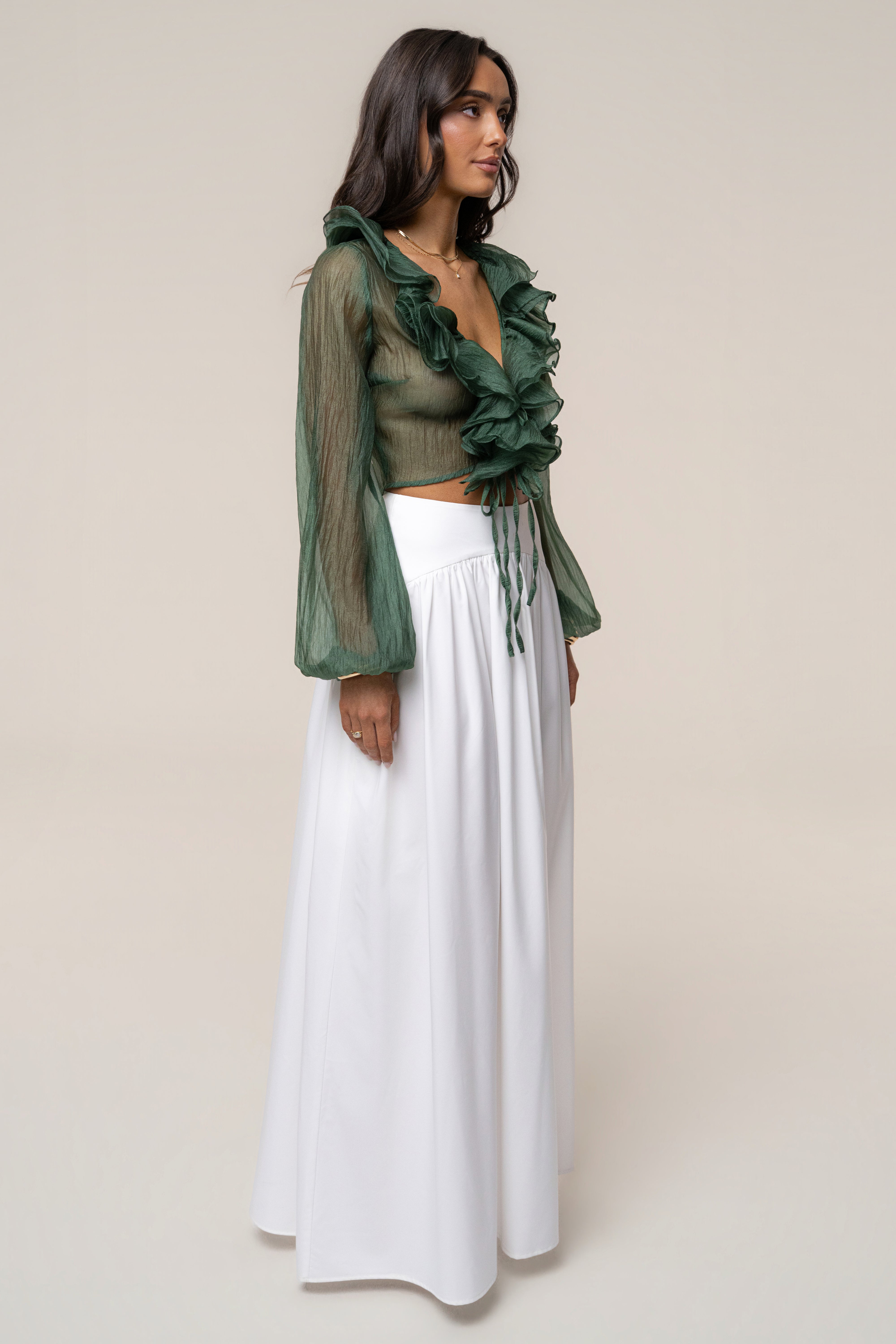 Side profile of model wearing green sheer ruffled Delilah top