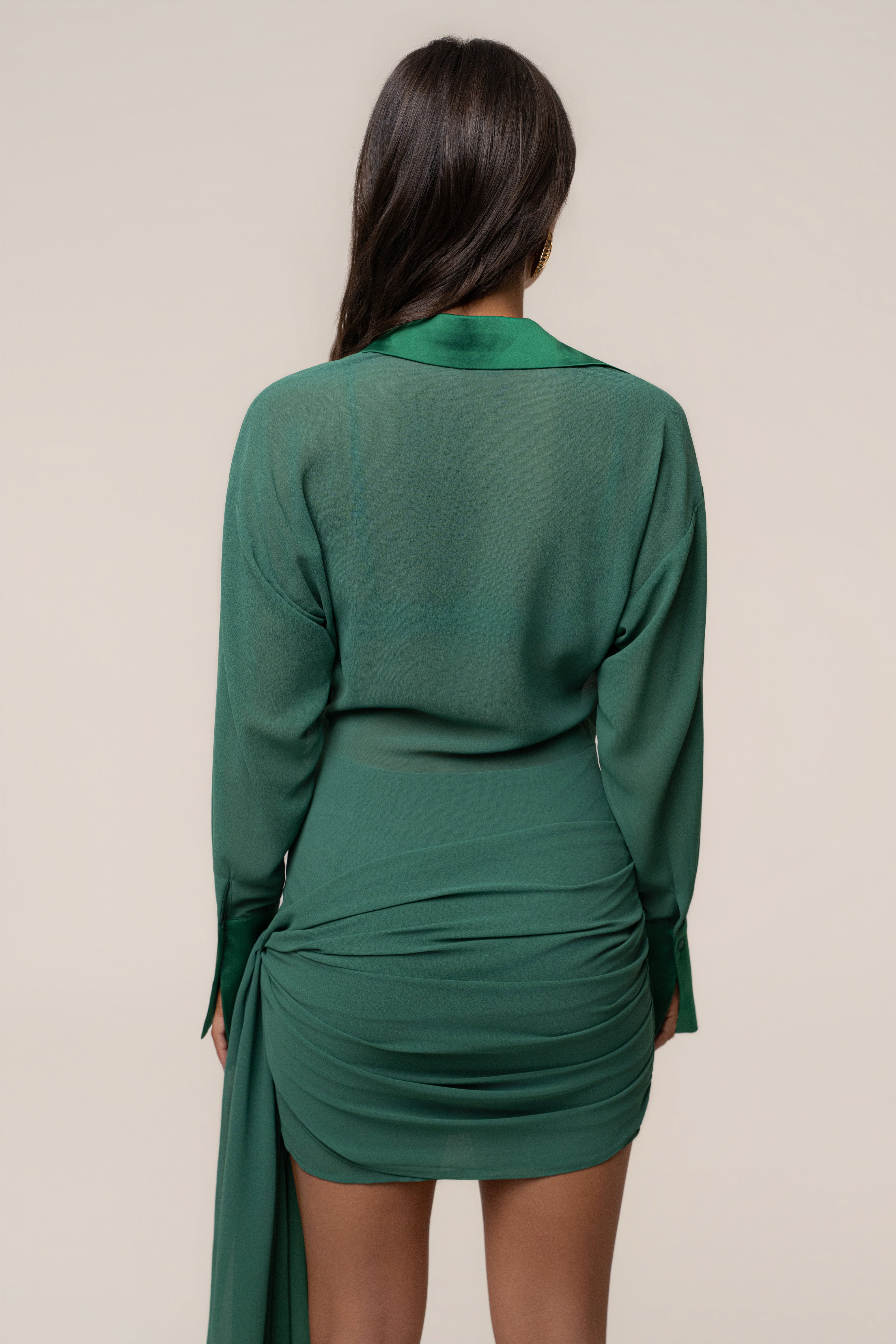Back view of forest green satin mini dress with long sleeves and a wrapped draped waist.