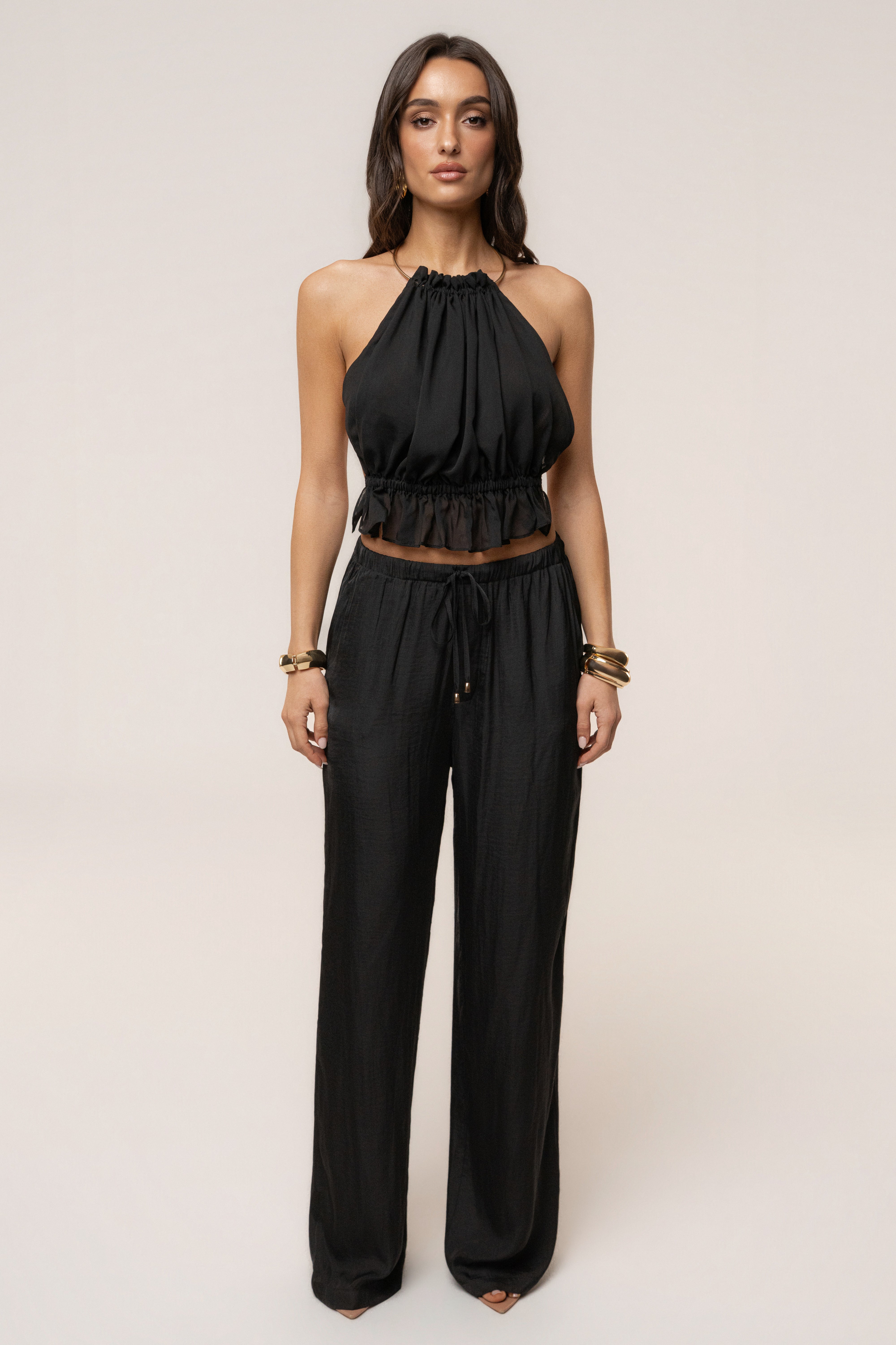 Black Seaside Glow pants by JLUXLABEL, stylish bottoms with a relaxed fit and seaside-inspired design, shown on a model.