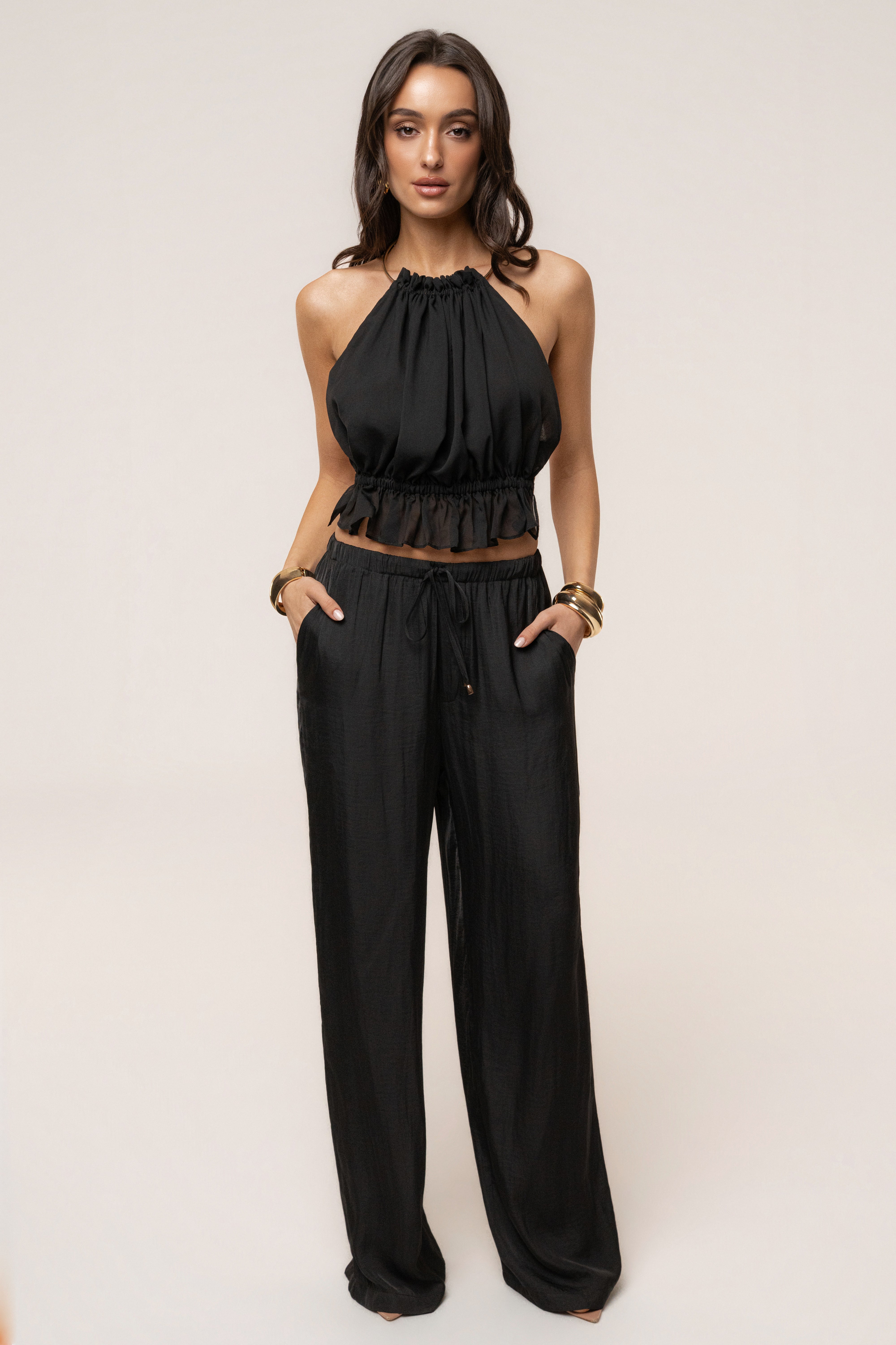 Black Seaside Glow Pants from JLUXLABEL, stylish bottoms with a relaxed fit, featuring a glossy seaside-inspired fabric design.