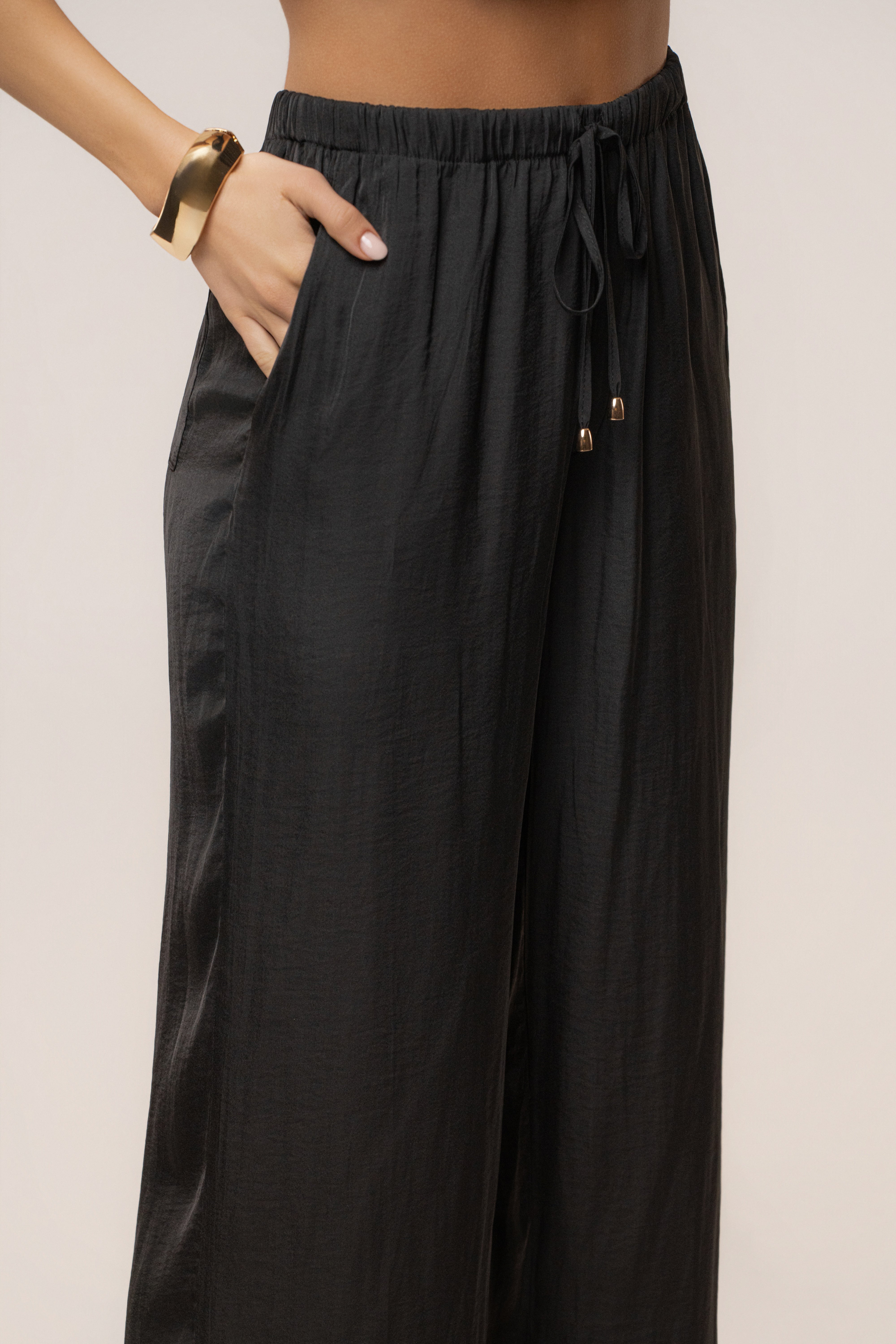 Black Seaside Glow Pants by JLUXLABEL, stylish bottoms with a relaxed fit and ocean-inspired design, shown on a model.