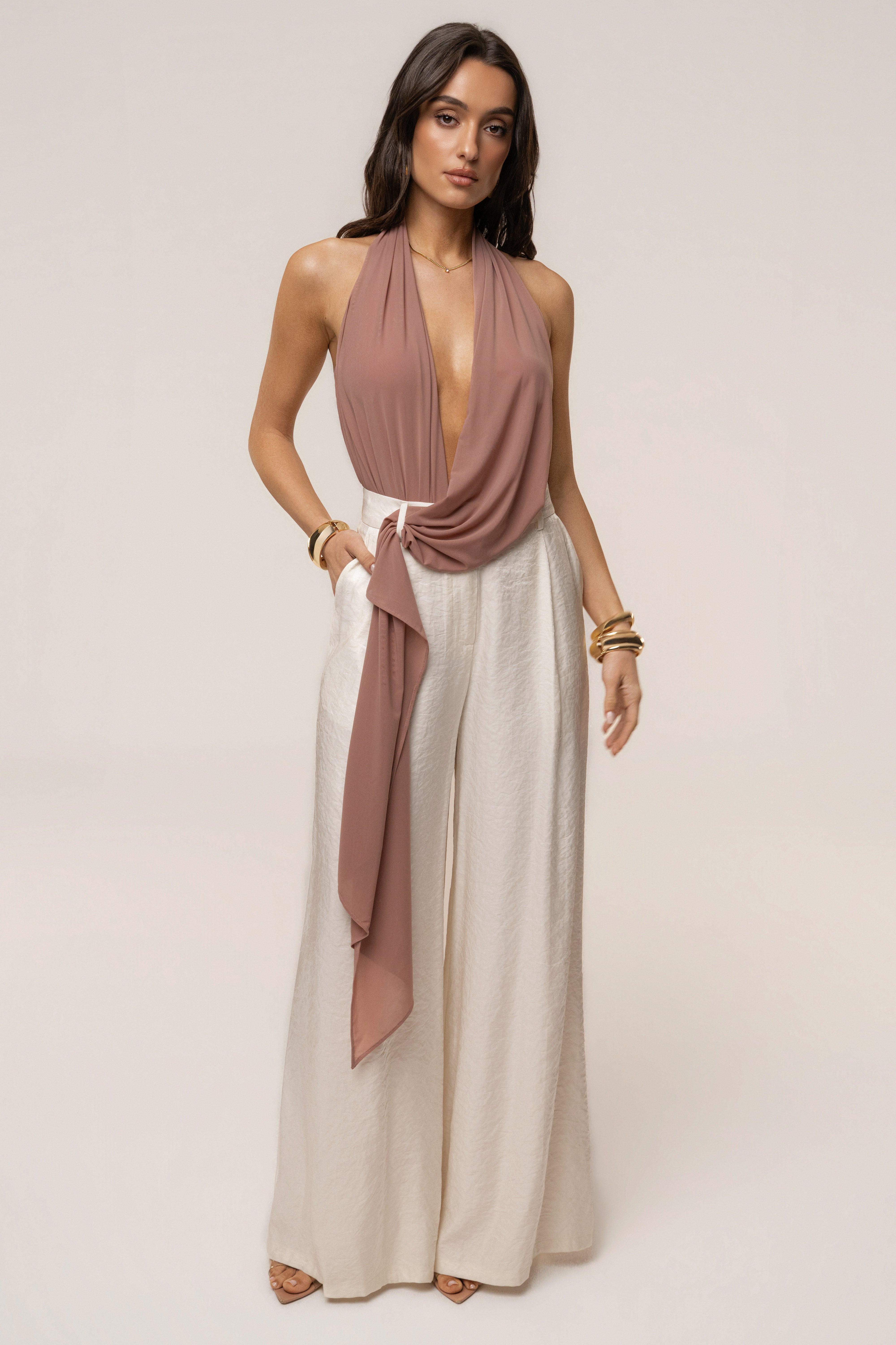 Dusty rose bare form plunge bodysuit by JLUXLABEL, featuring a deep V neckline and seamless fit, styled as a trendy top.