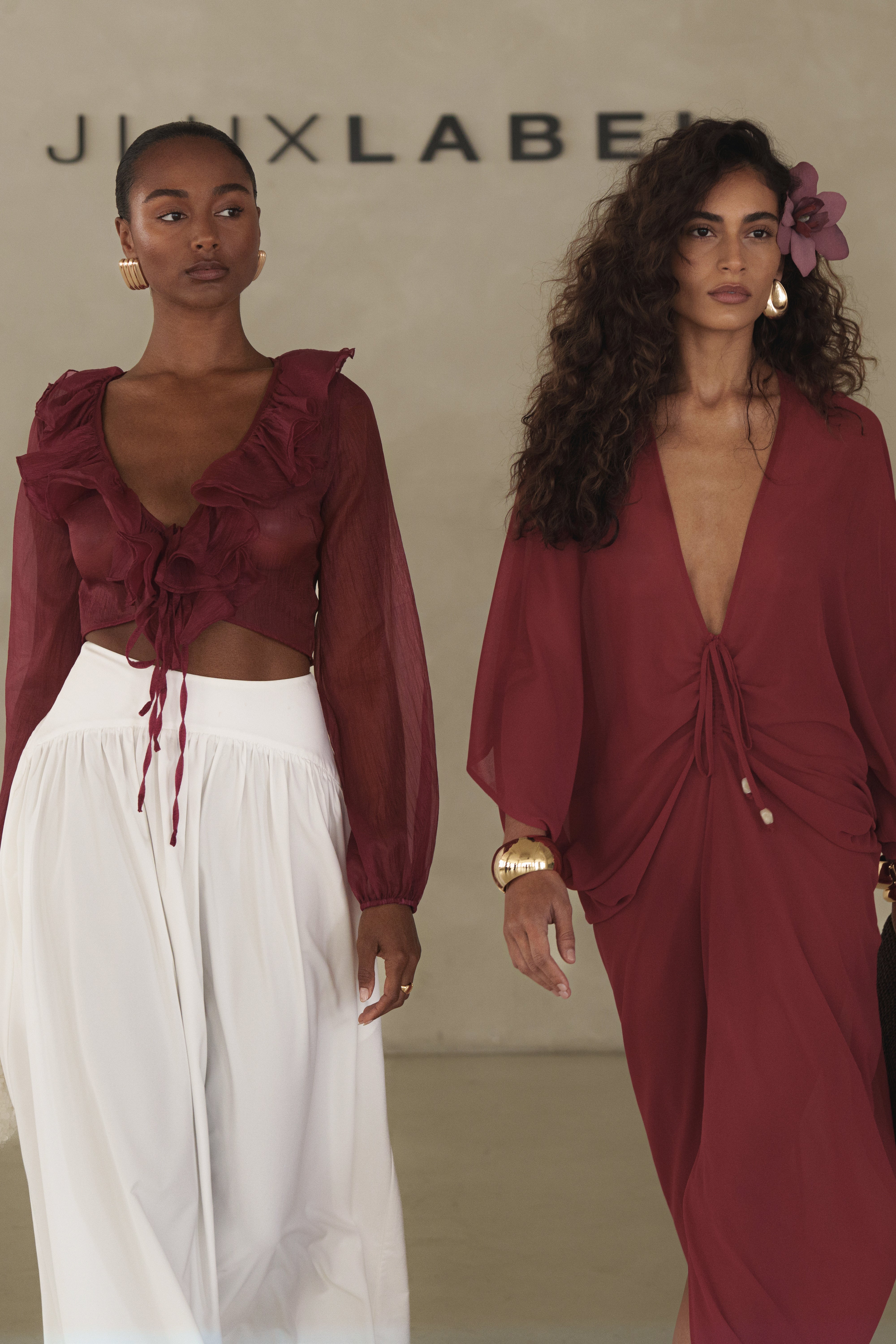 Profile view of a model in a burgundy Berry Delilah Ruffled Top with a deep V neckline and front ties.