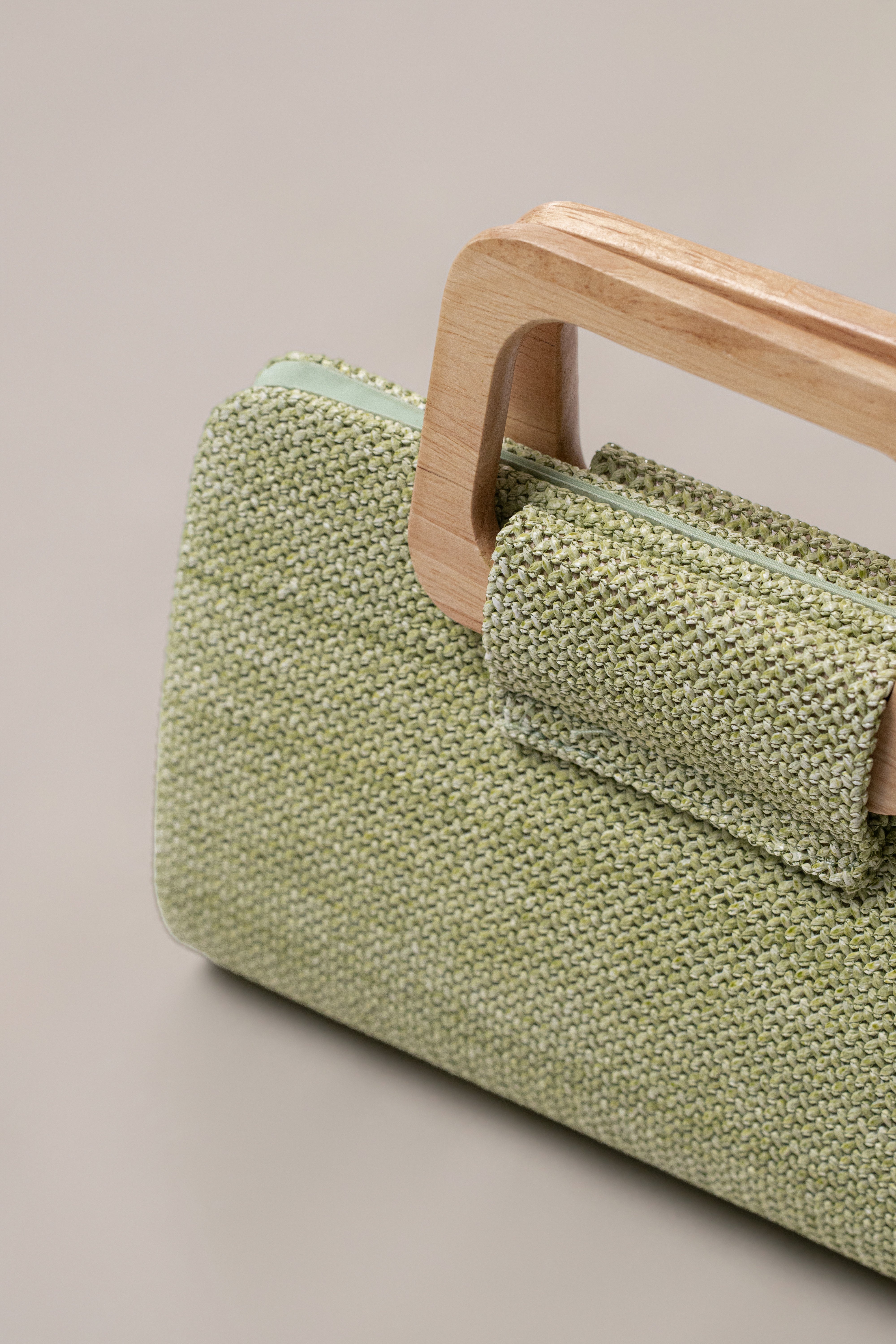 Sage Isola clutch by JLUXLABEL featuring a sleek, stylish design with a fold-over flap and metallic accents.