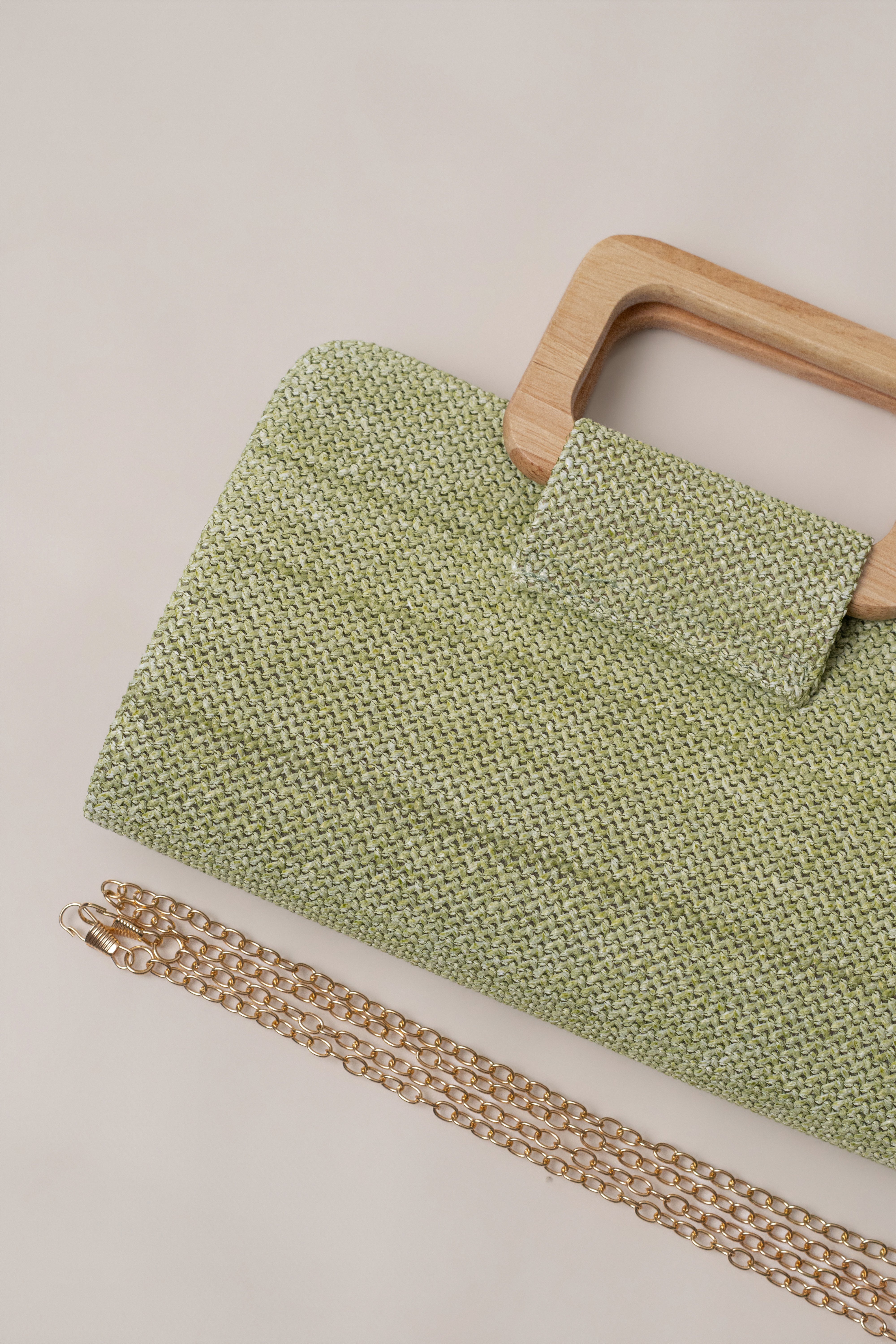 Sage Isola clutch by JLUXLABEL, stylish accessories with a sleek design, featuring a textured surface and elegant shape.