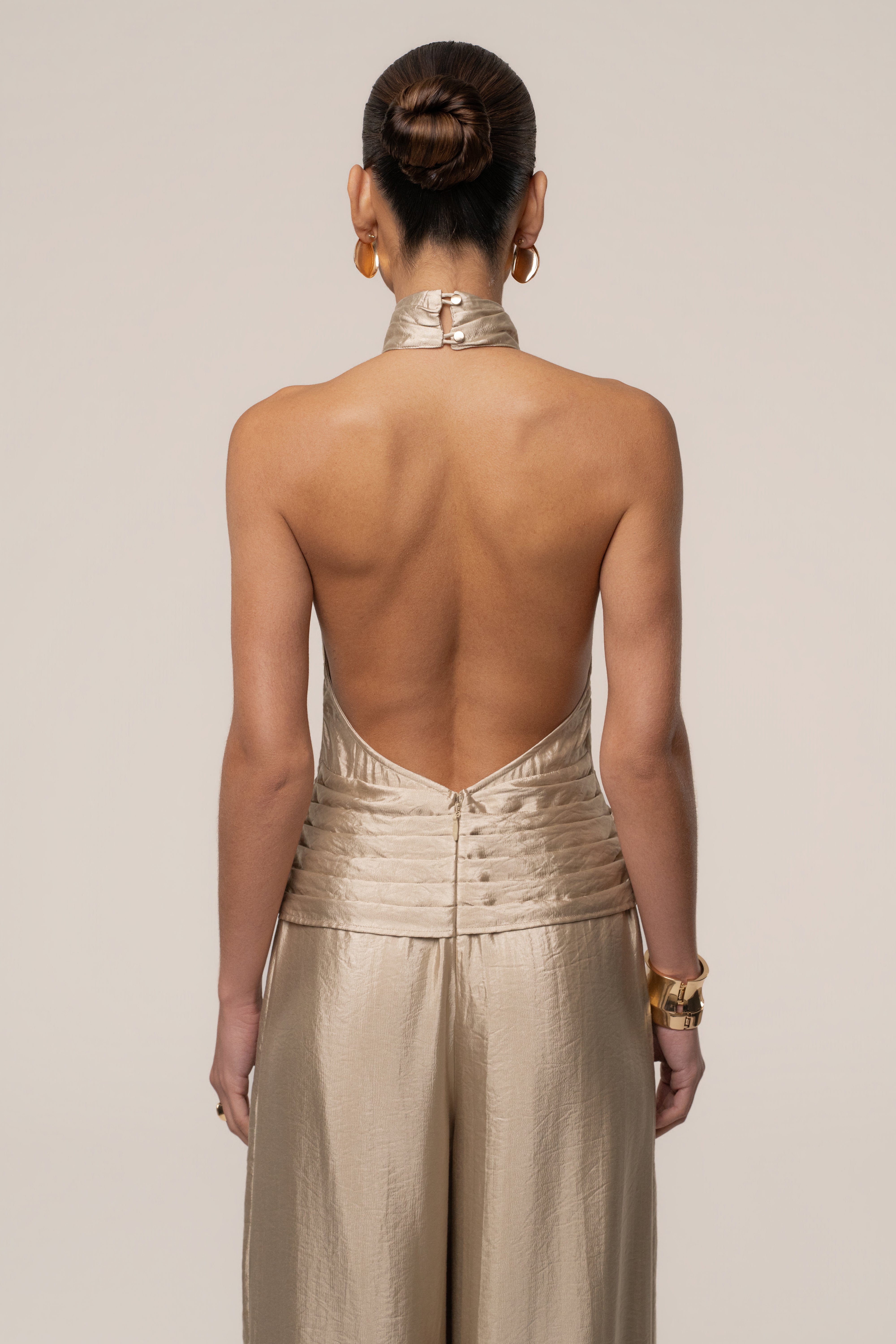 Gold accent JLUXLABEL jumpsuit styled for modern fashion, featuring sleek design and elegant details.