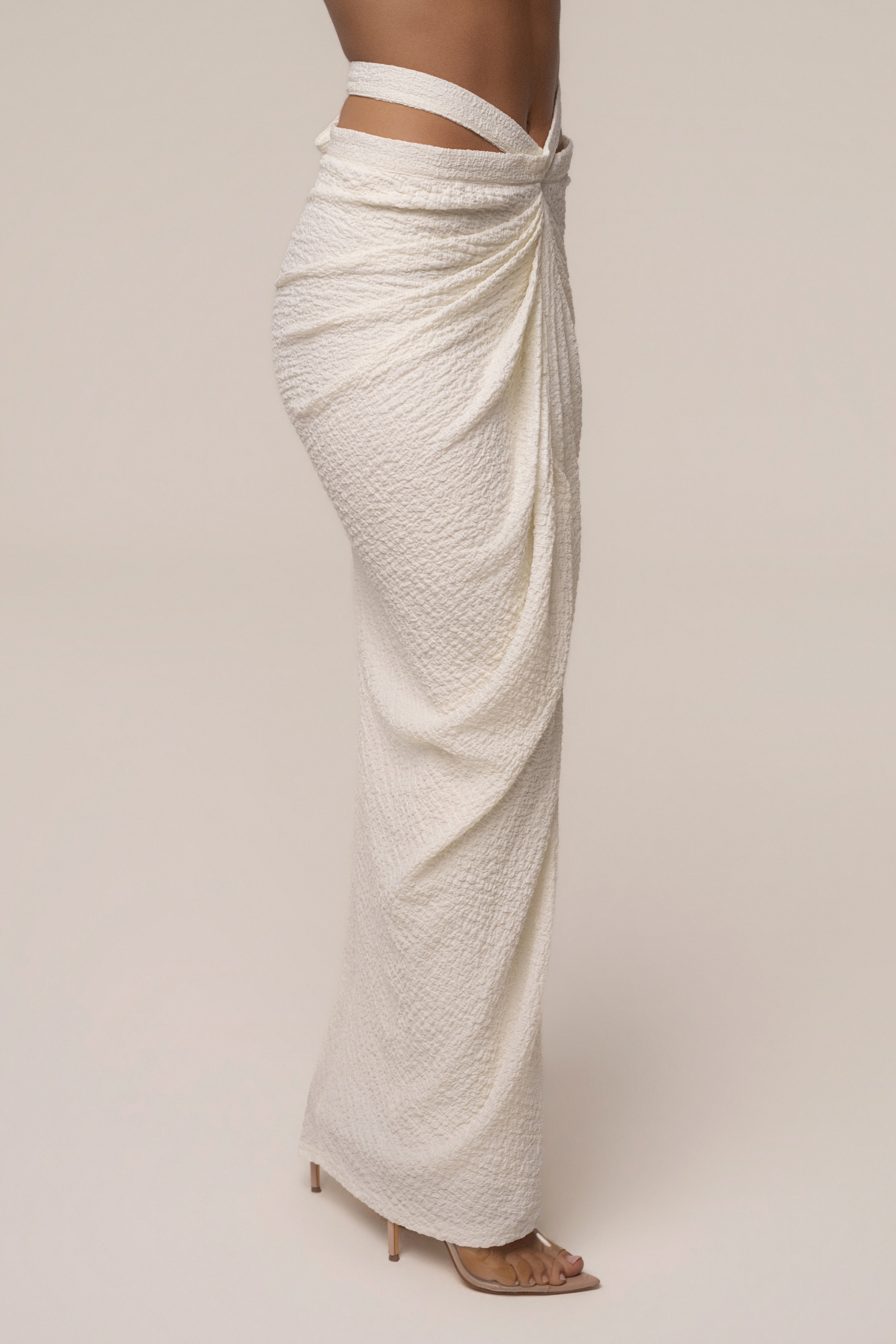 Ivory textured wrap maxi skirt with draped front and side slit shown in profile