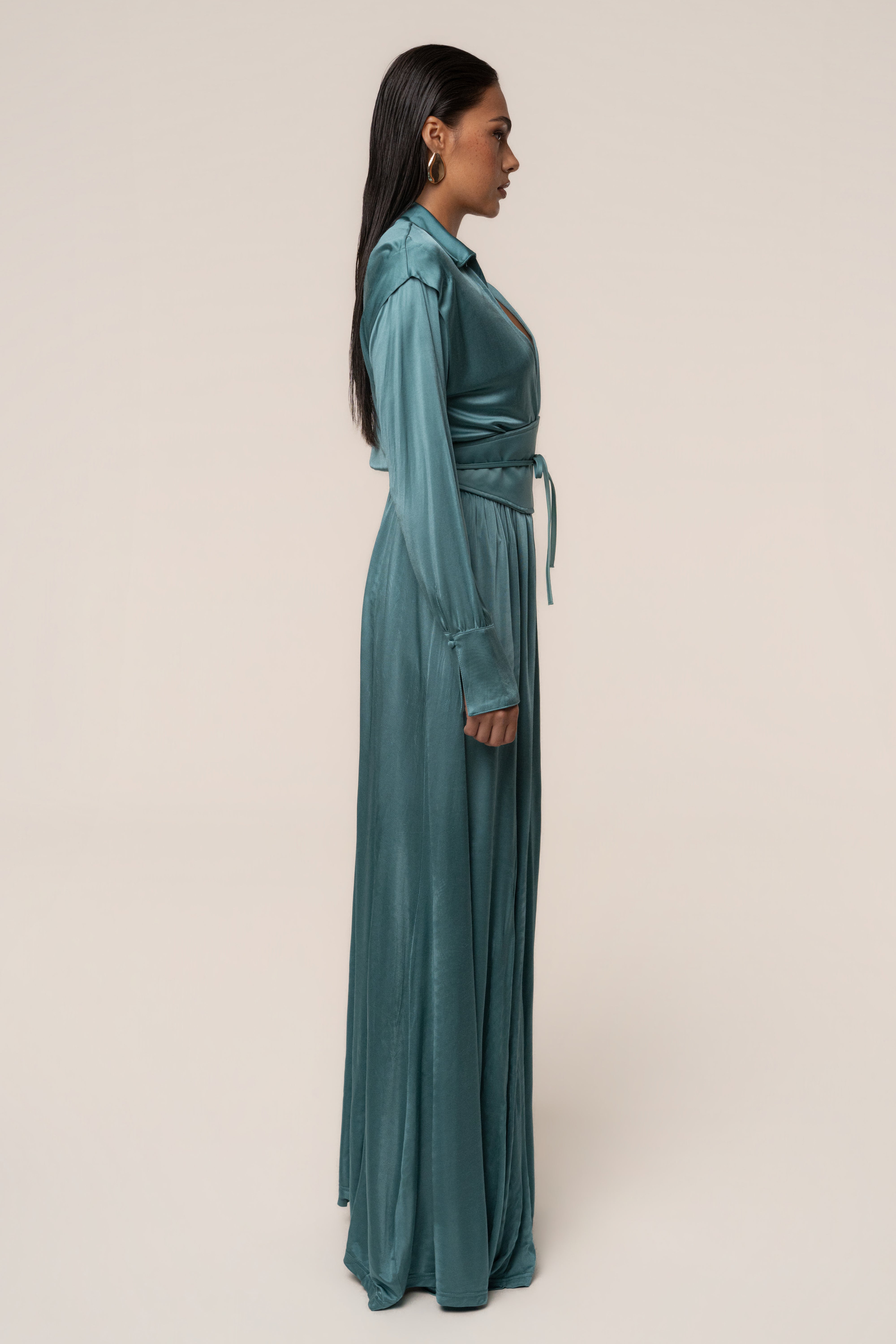 Teal JLUXLABEL High Line Collar Maxi Dress displayed on a hanger, showcasing its elegant design and flowing fabric.