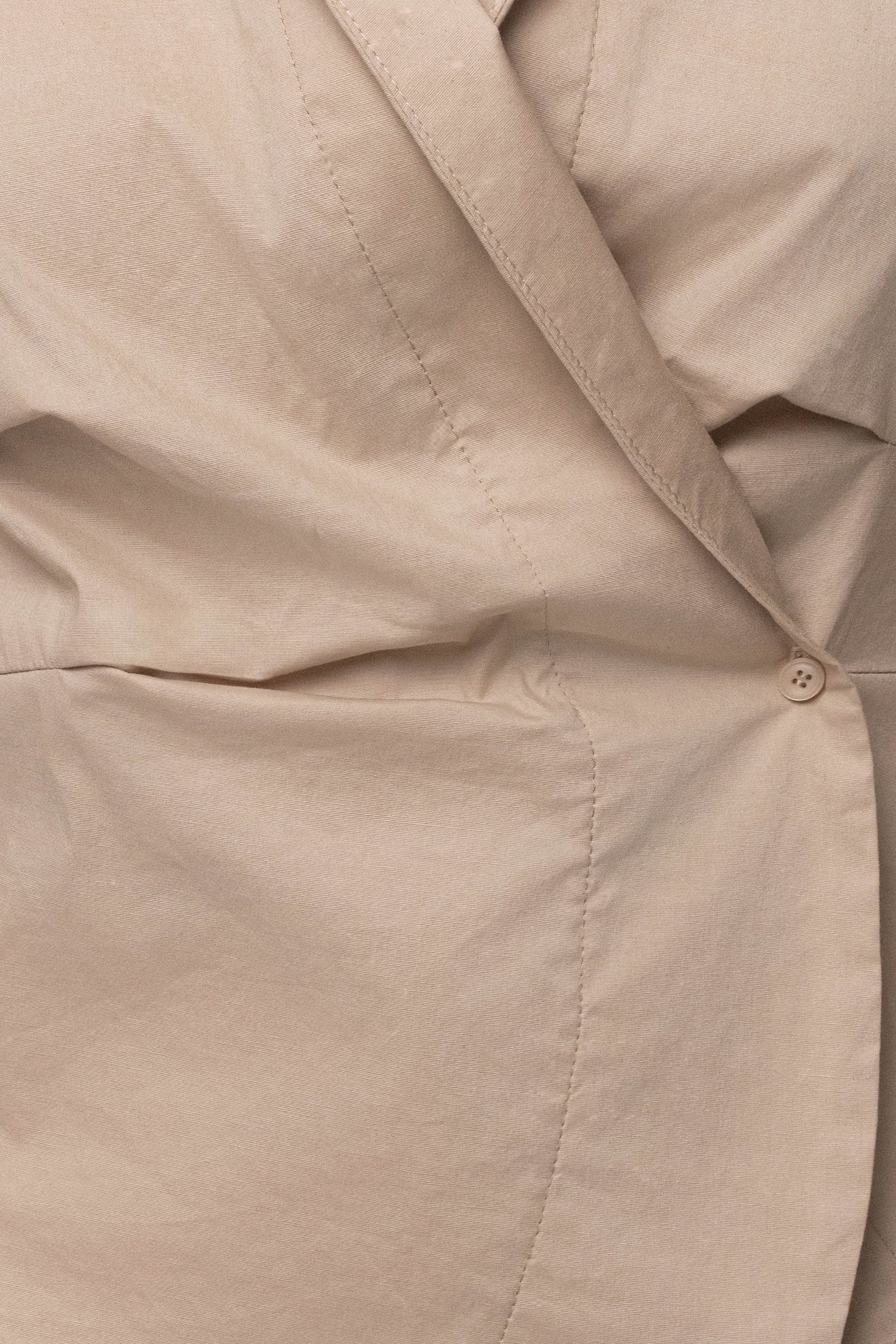 Beige Sculpt and Form blouse from JLUXLABEL, stylish top with a flattering fit, displayed on a hanger against a neutral background.