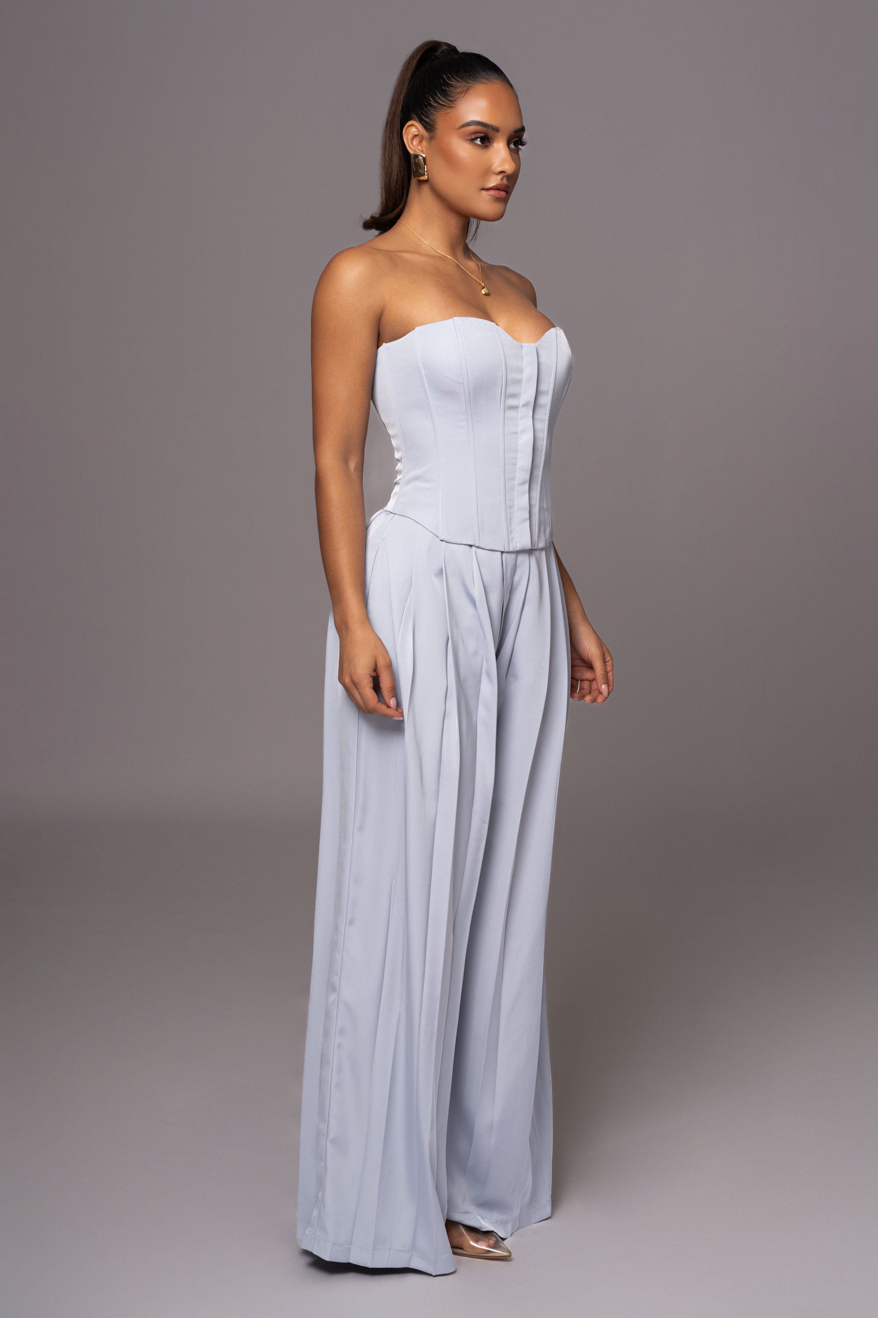 Blue Clara wide-leg pleated trousers by JLUXLABEL, showing the flowing fabric and tailored fit in a casual styling shot.