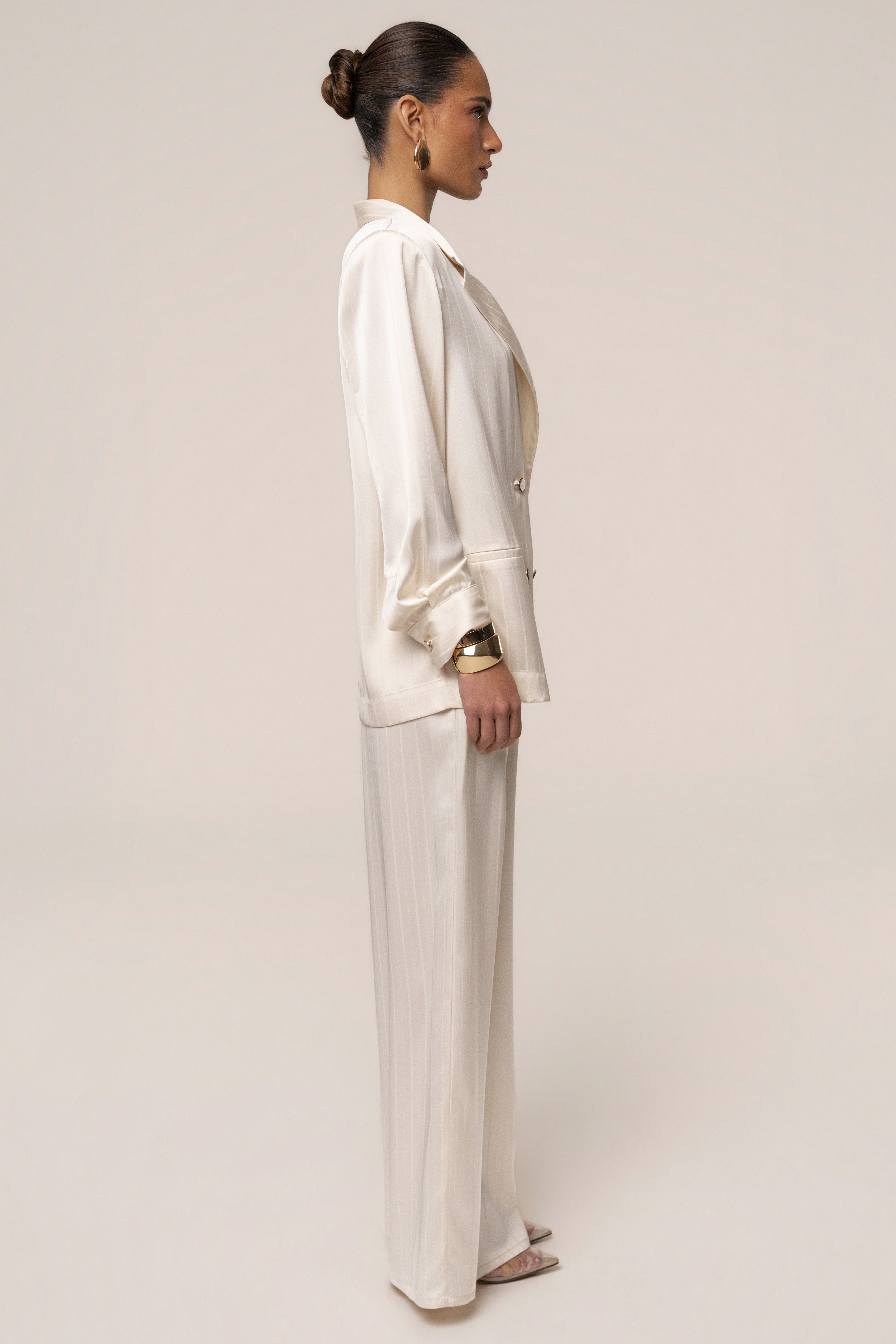 Ivory JLUXLABEL The Standard blazer, a stylish women's top with a tailored fit and lapel collar, displayed on a hanger.