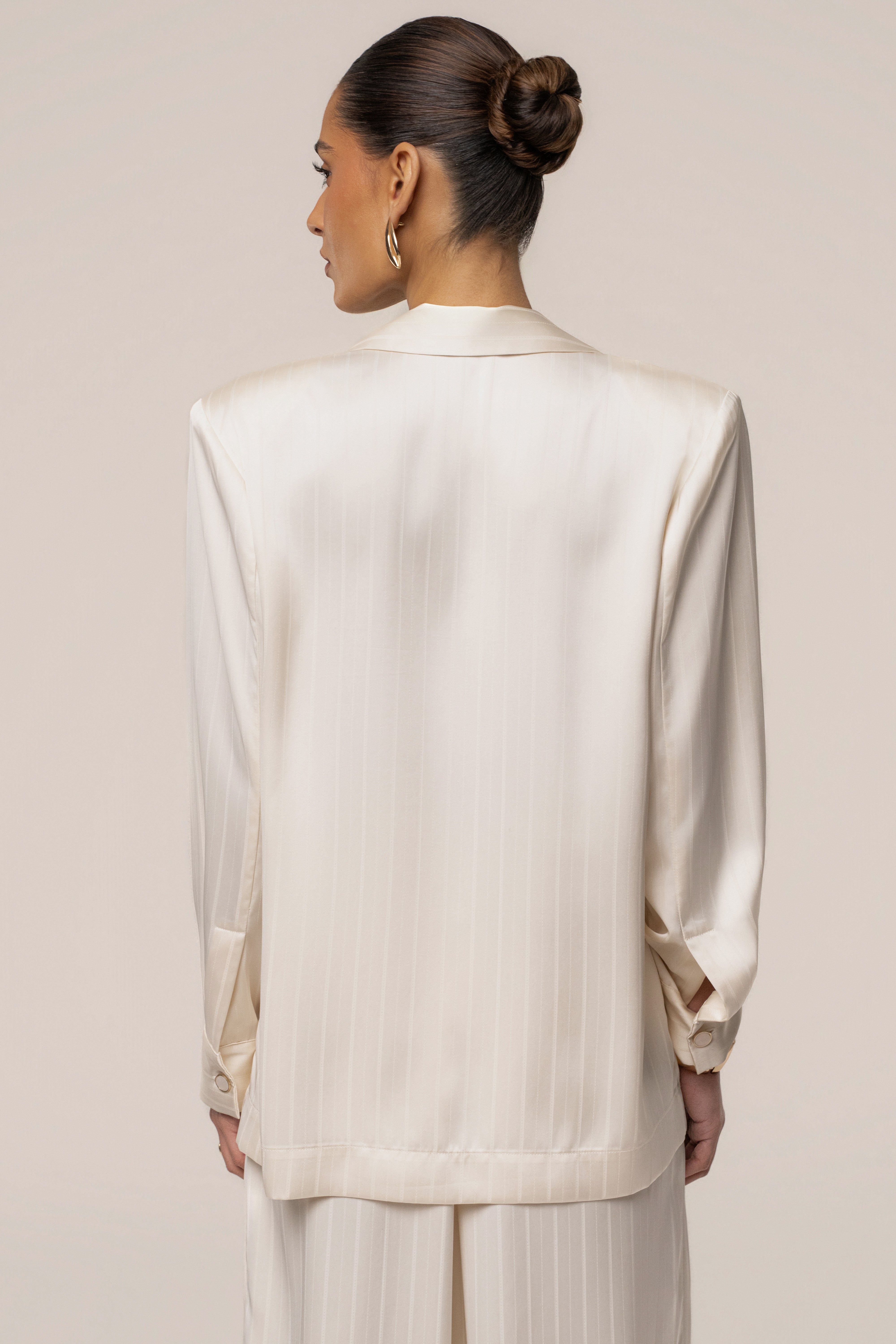 Ivory JLUXLABEL The Standard blazer shown on a hanger, featuring a tailored fit and classic design in a stylish tops collection.