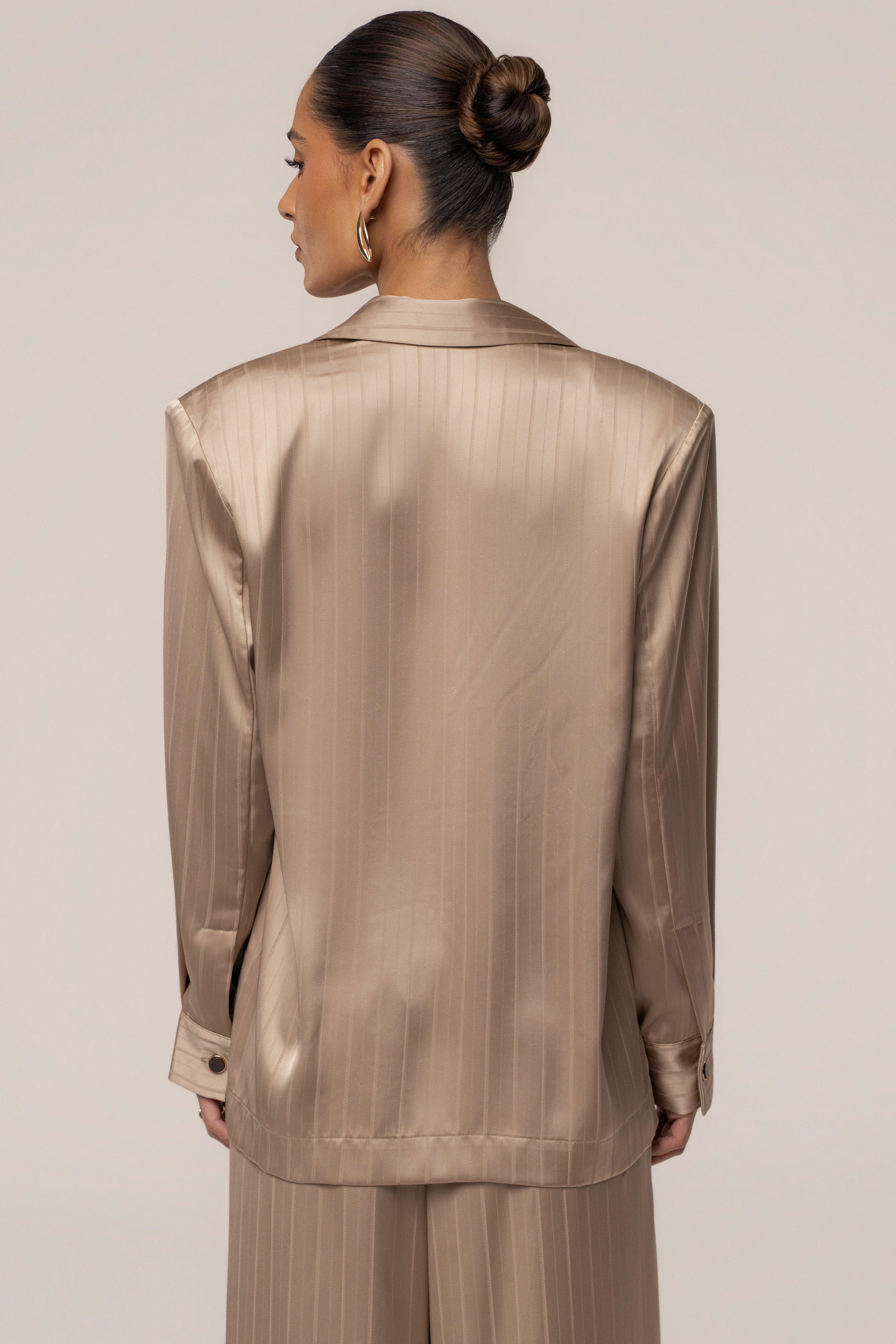 JLUXLABEL Stone The Standard blazer, a stylish women's top in a neutral stone color, displayed on a hanger.