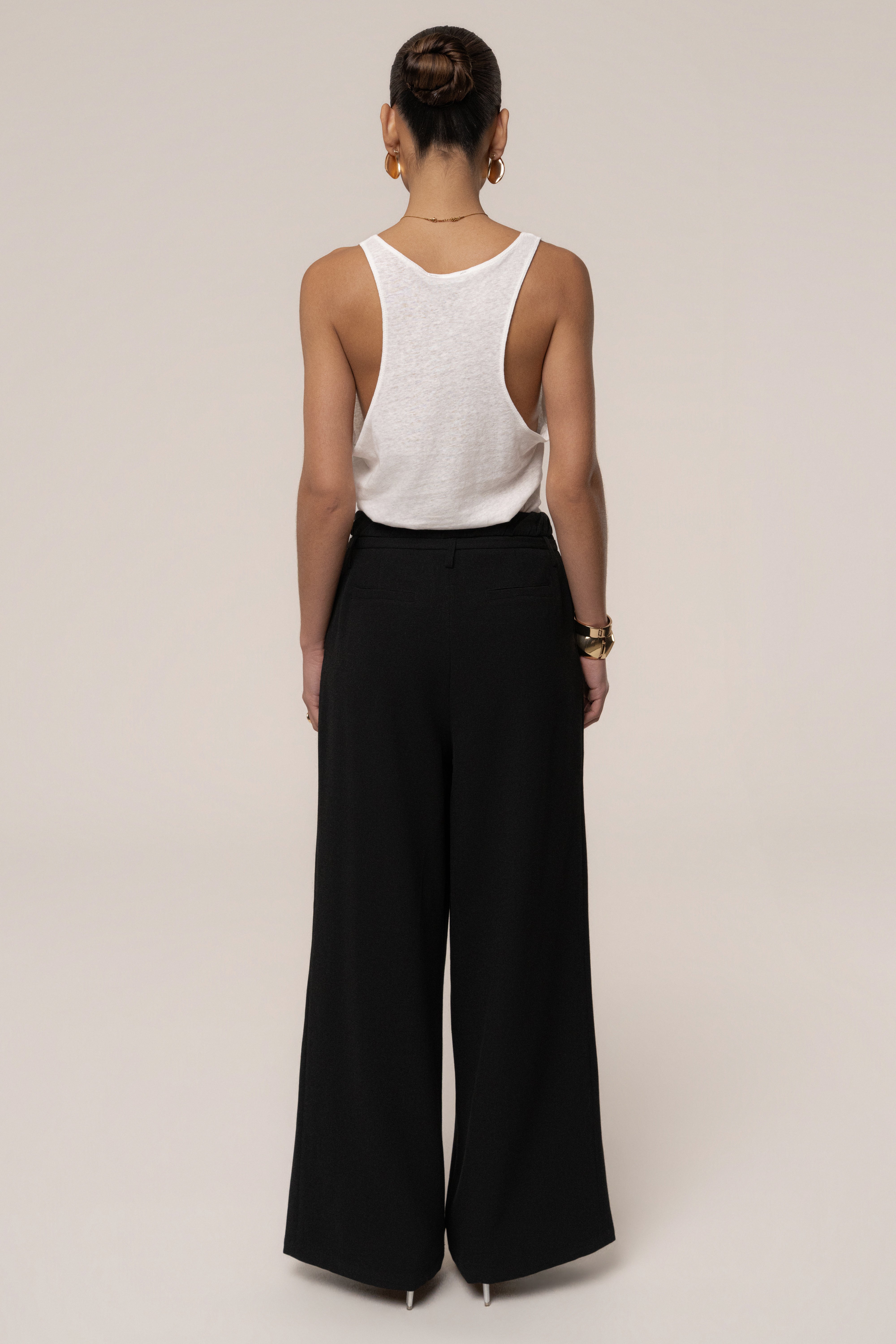 Black JLUXLABEL refined wide-leg pants made of soft fabric, featuring a high waist and relaxed fit, shown on a model.