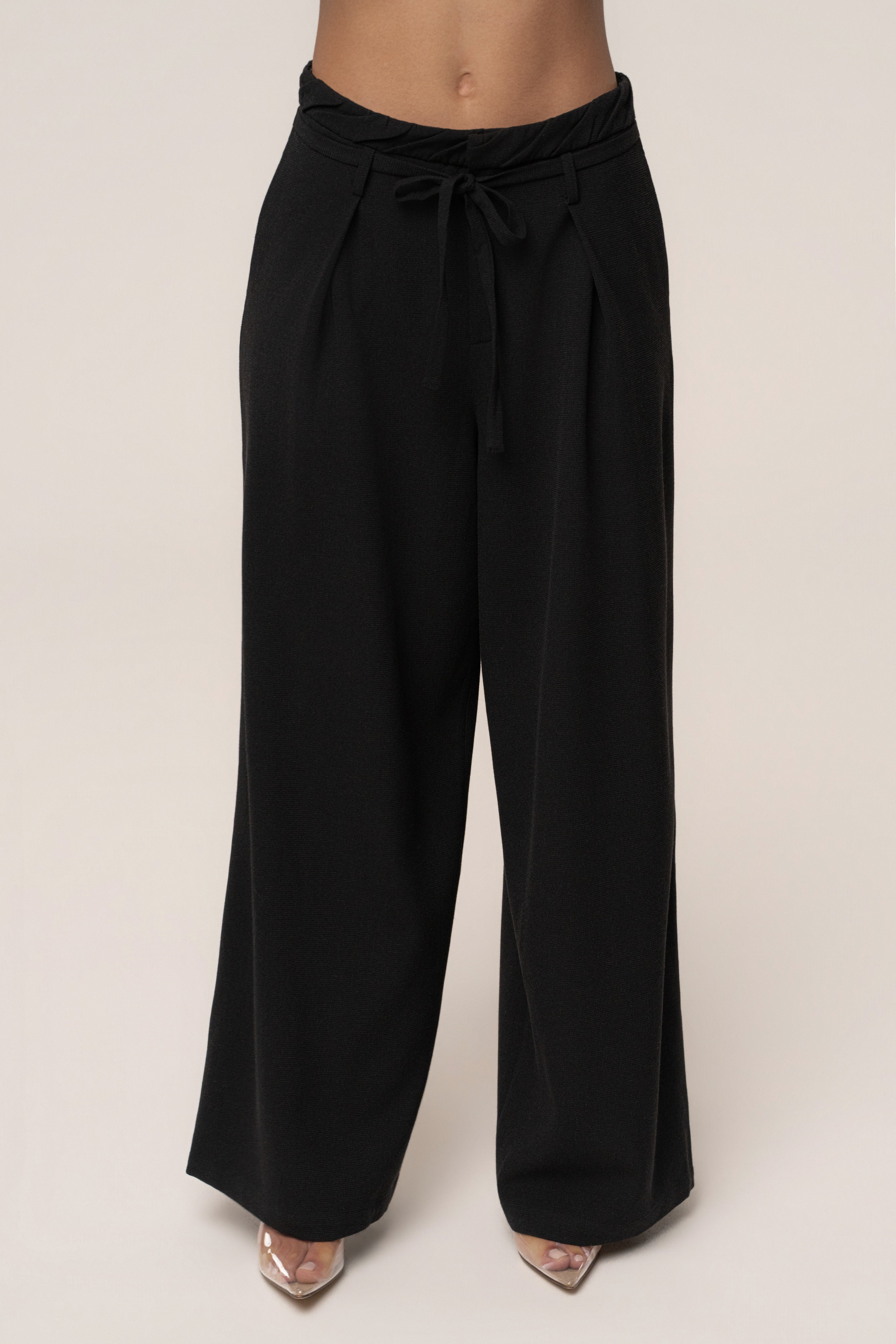 Black JLUXLABEL Refined Ease wide leg pants shown with a focus on the relaxed fit and smooth fabric detail.