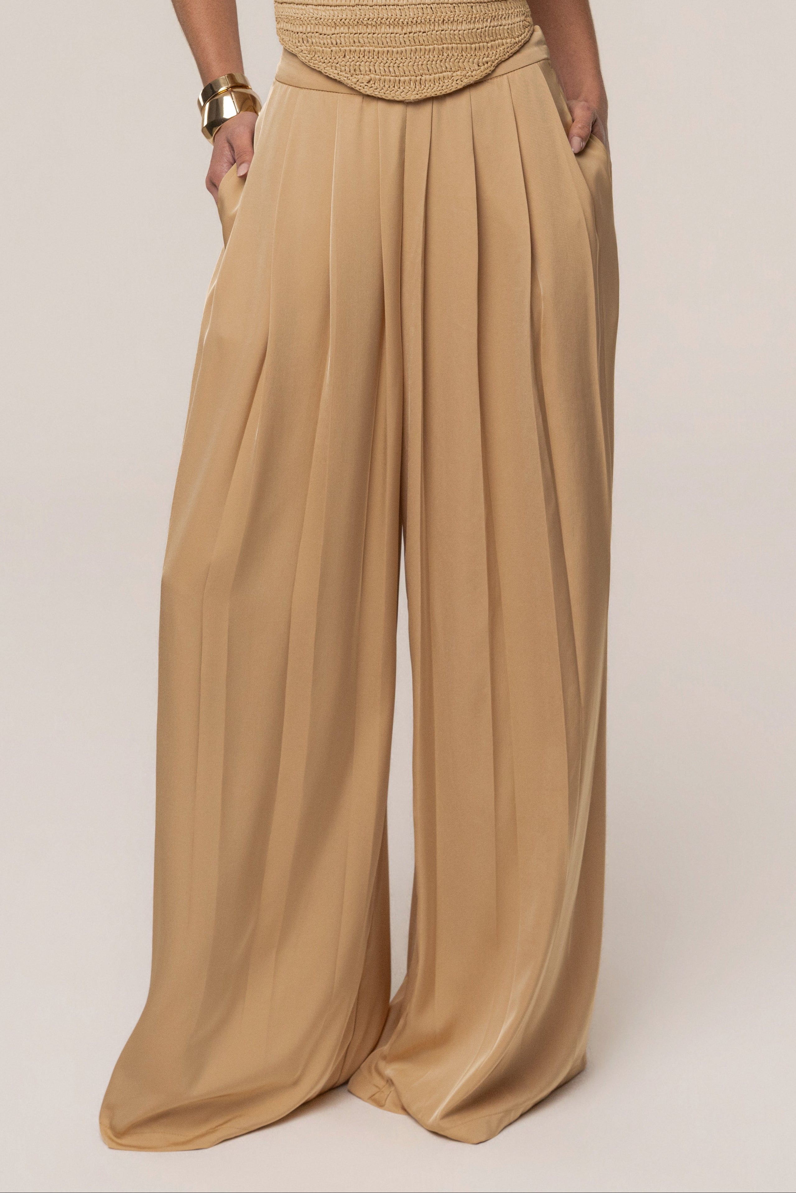 Beige JLUXLABEL Clara wide leg pleated trousers with a high waist and flowing fabric, styled as stylish women's bottoms.