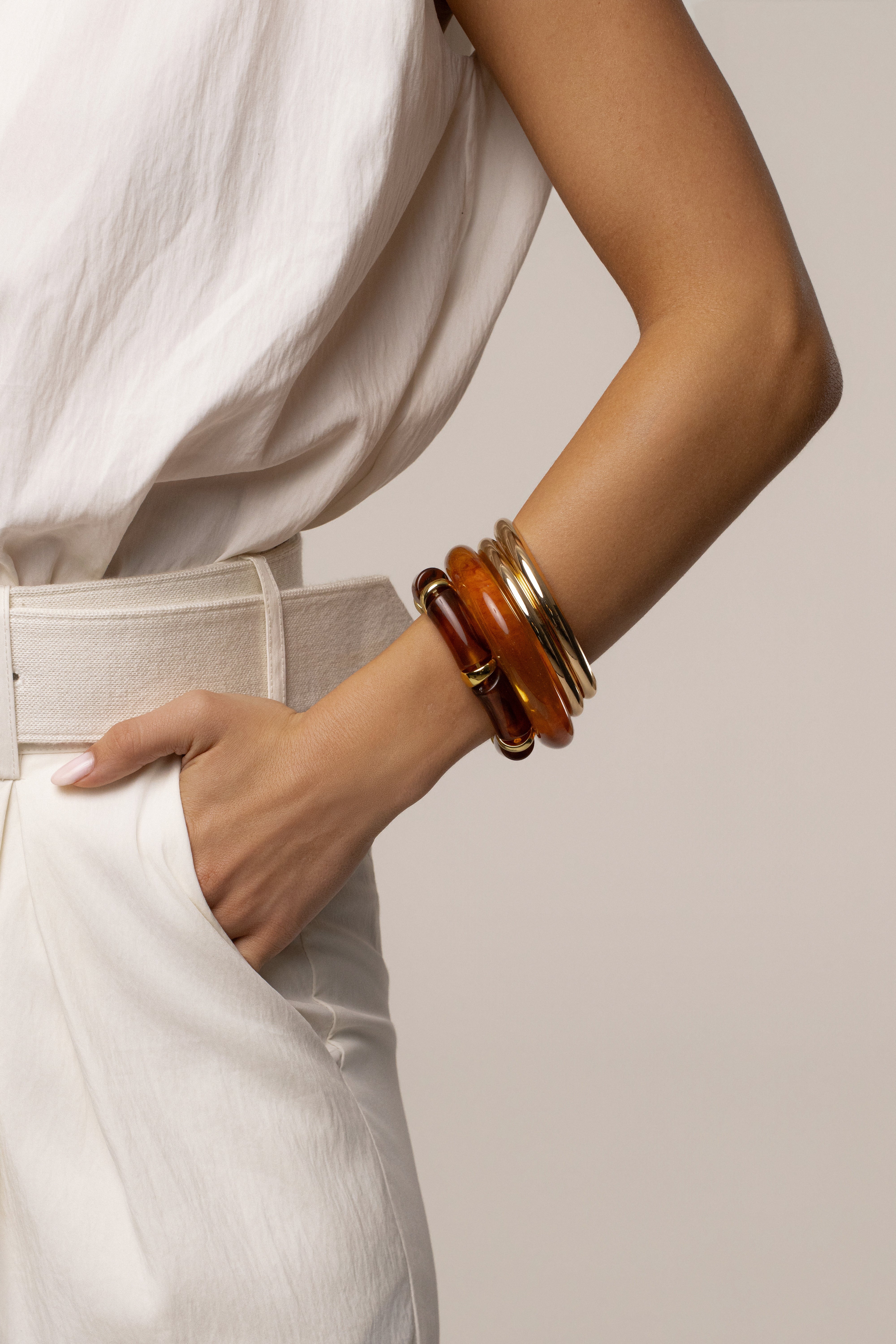 Gold vacation bracelet set by JLUXLABEL featuring layered jewelry with delicate chain and charm accents.