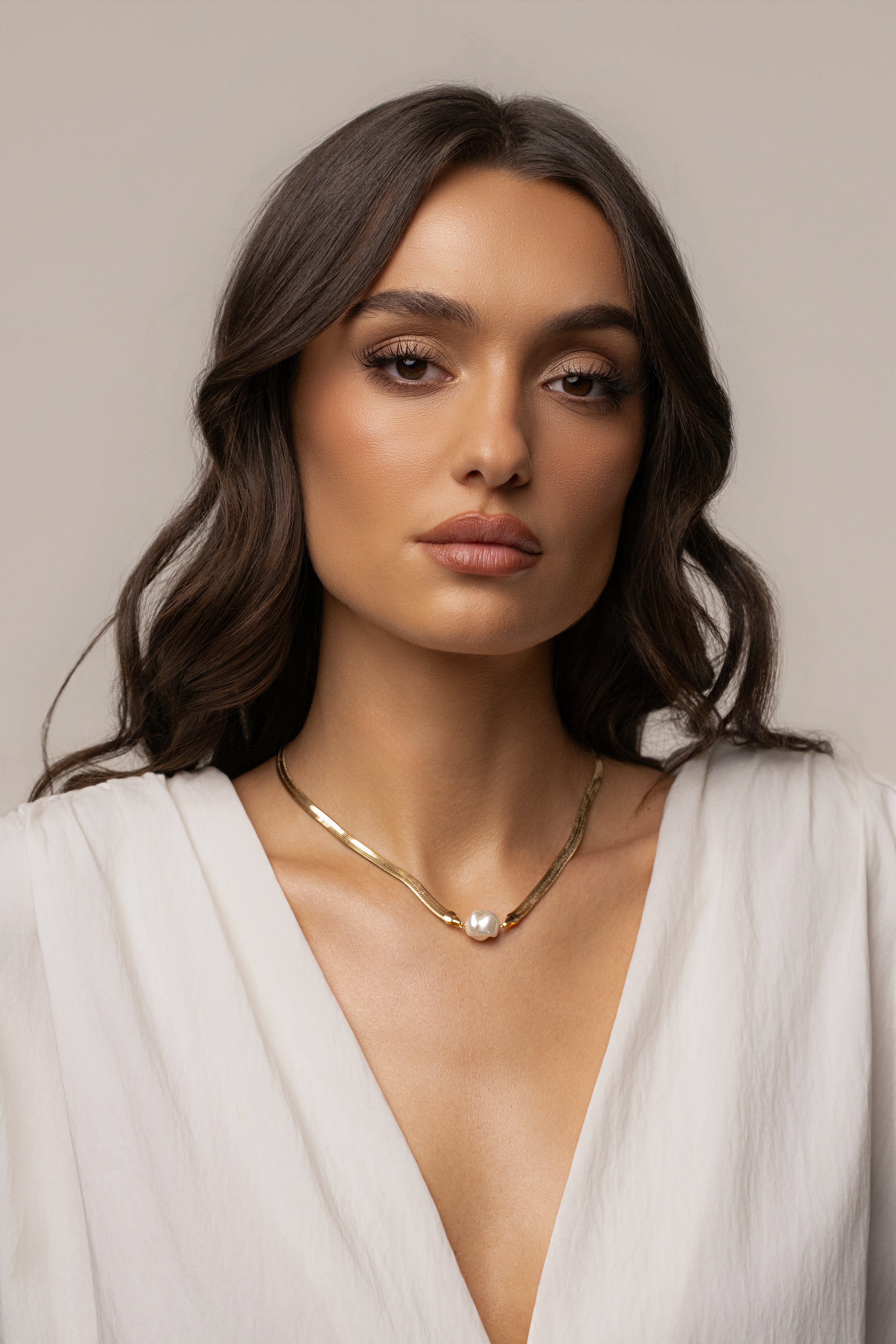 Gold pearl herringbone necklace featuring a sleek chain design from JLUXLABEL, close-up view of the elegant jewelry piece.