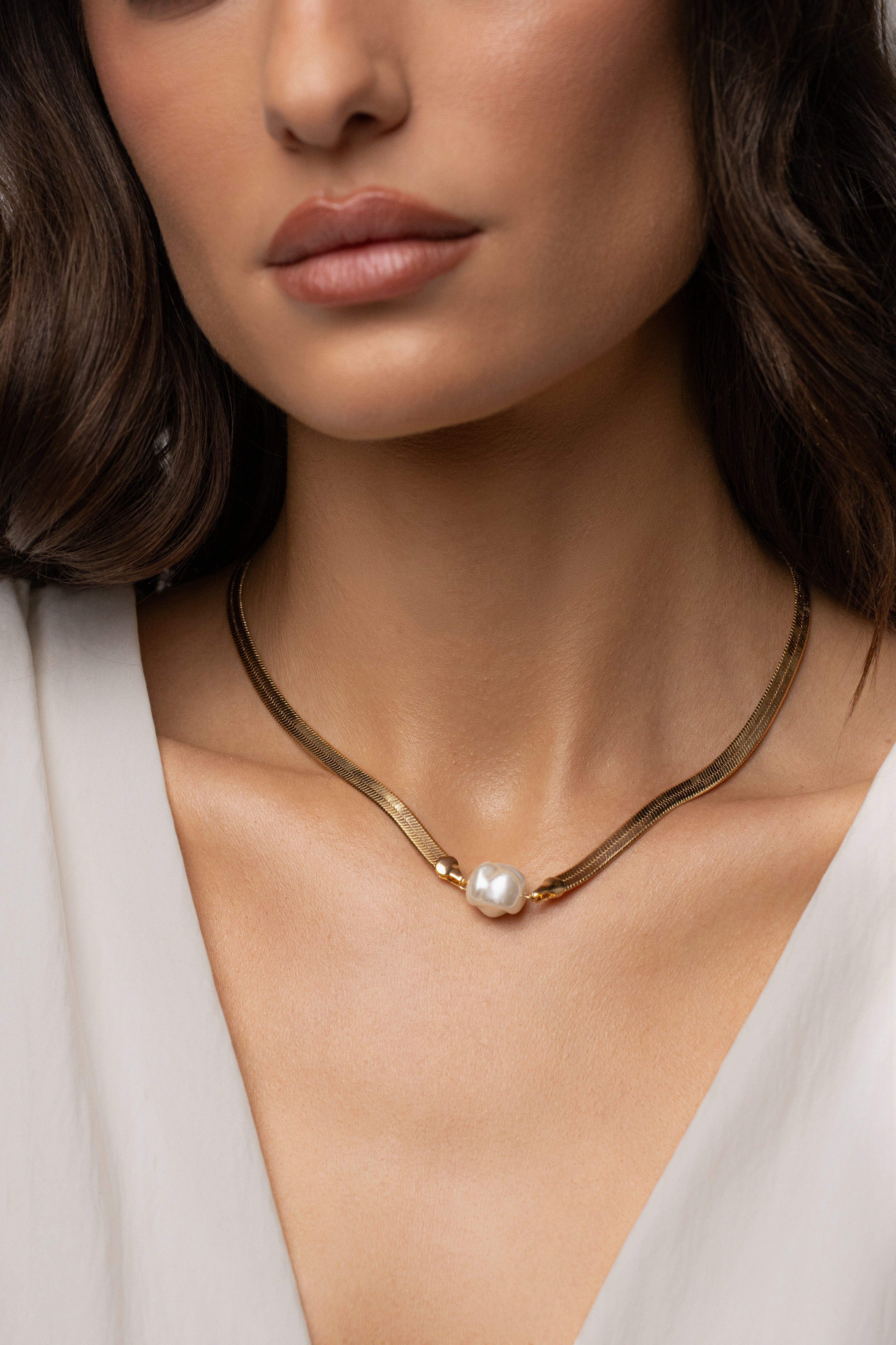 Gold pearl herringbone necklace from JLUXLABEL featuring a sleek, elegant jewelry design with gold chain and pearl accents.