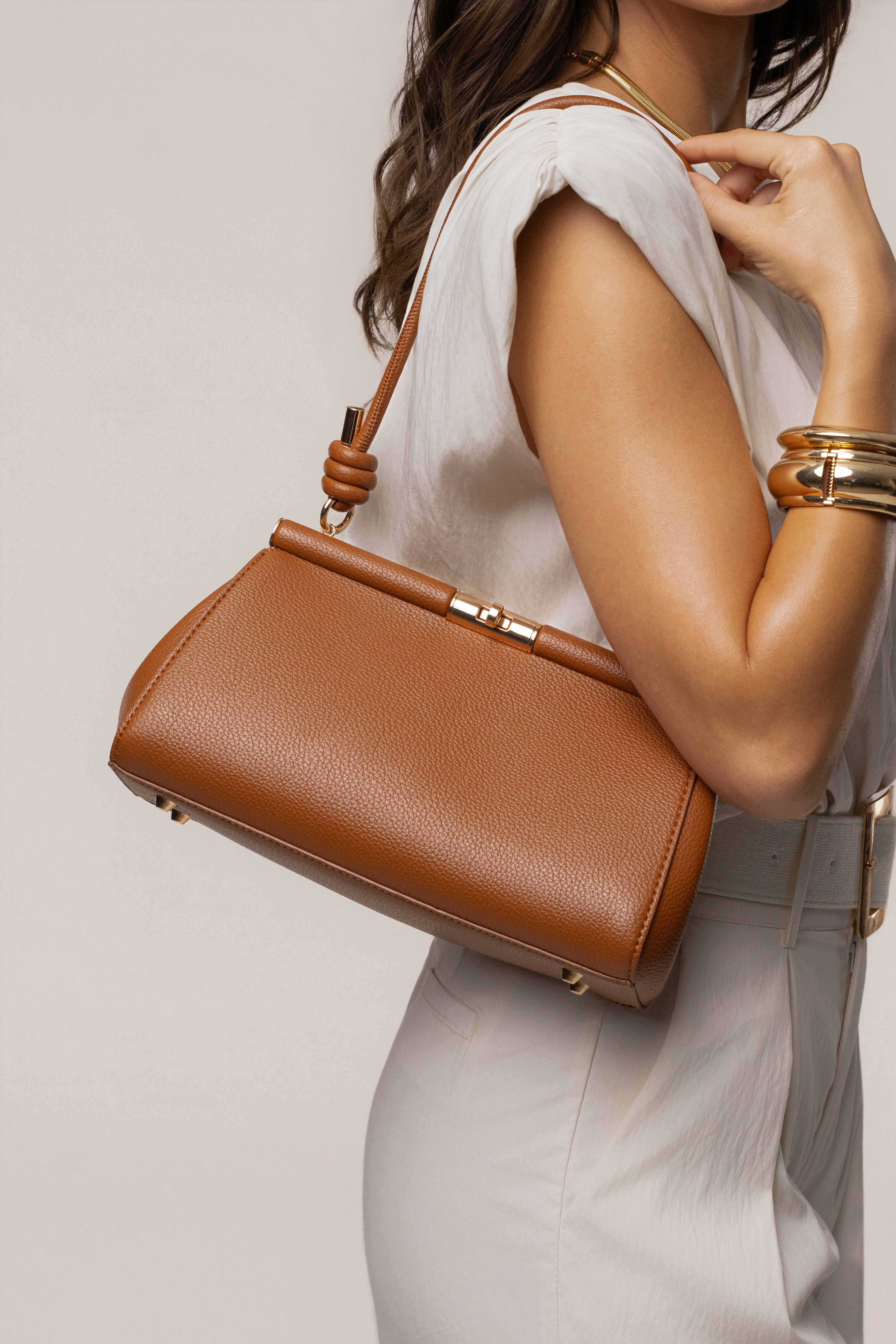 Brown Irene handbag by JLUXLABEL, featuring a stylish leather accessory with gold-tone hardware and top handle design.