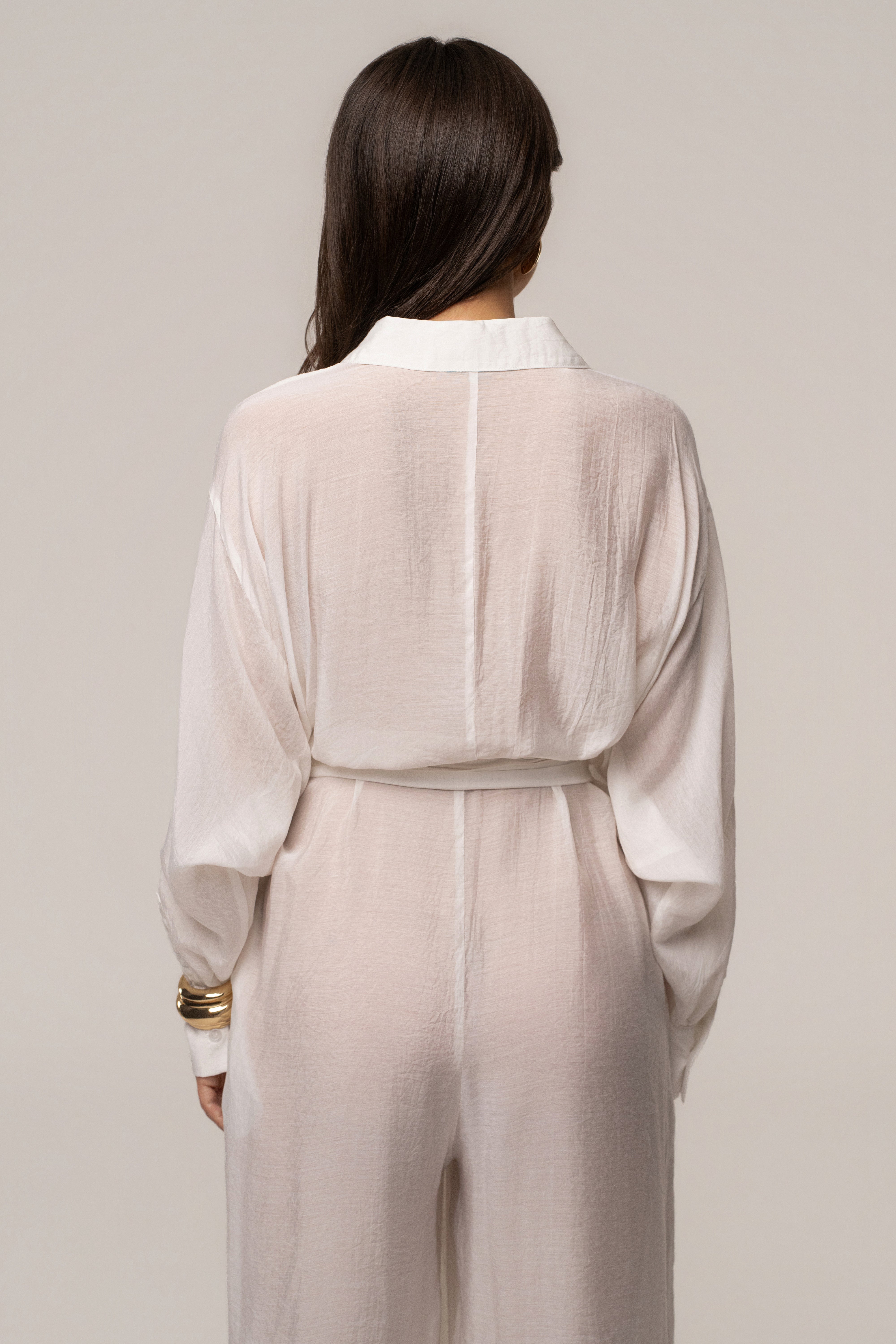Ivory JLUXLABEL Soho tailored jumpsuit with a fitted waist and wide-leg pants, displayed on a hanger against a neutral background.
