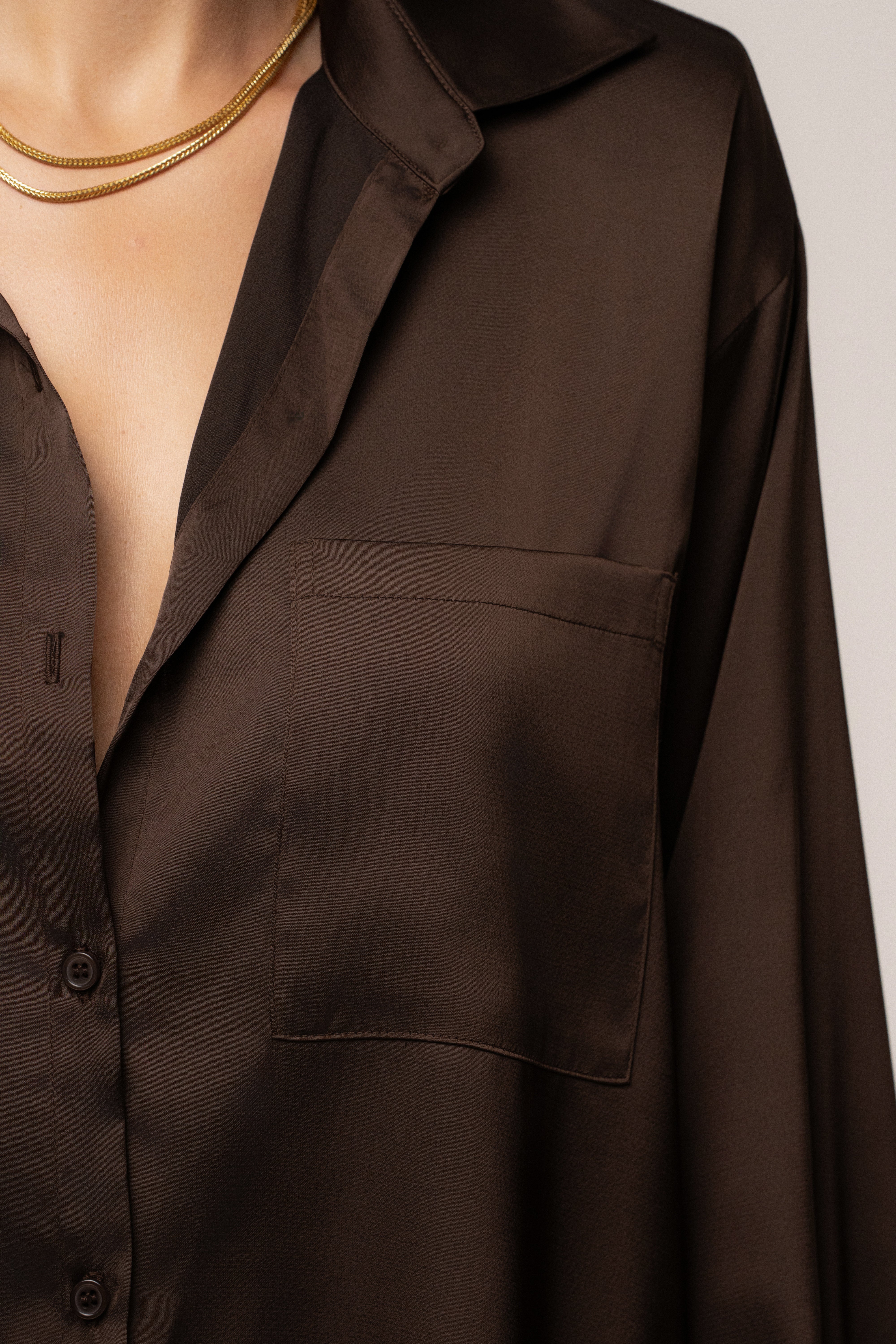 JLUXLABEL Chocolate Island Ease Collared Satin Top, stylish satin blouse with a collar, displayed on a hanger.
