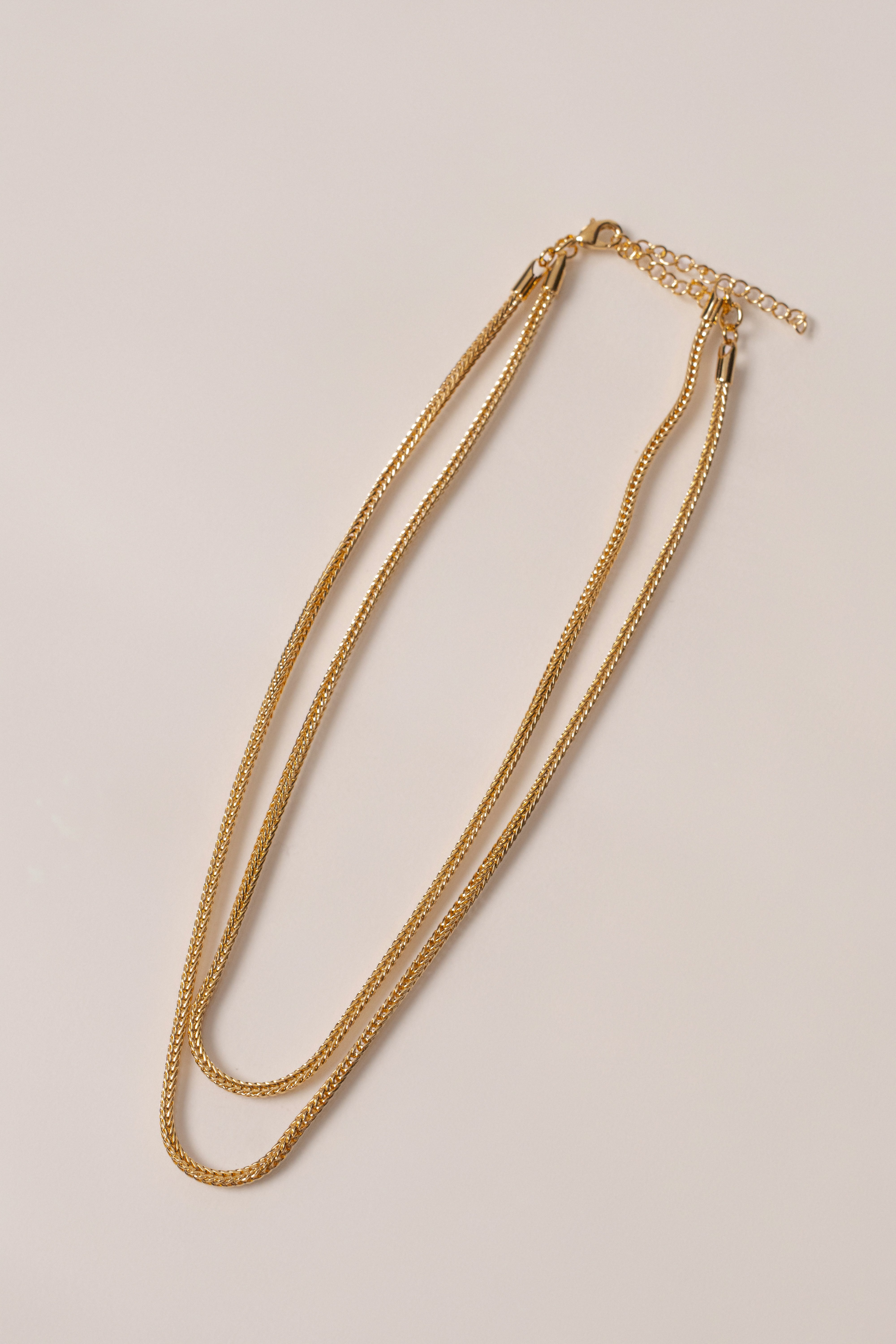 Gold double herringbone necklace by JLUXLABEL, showcasing a sleek, layered jewelry design on a white background.