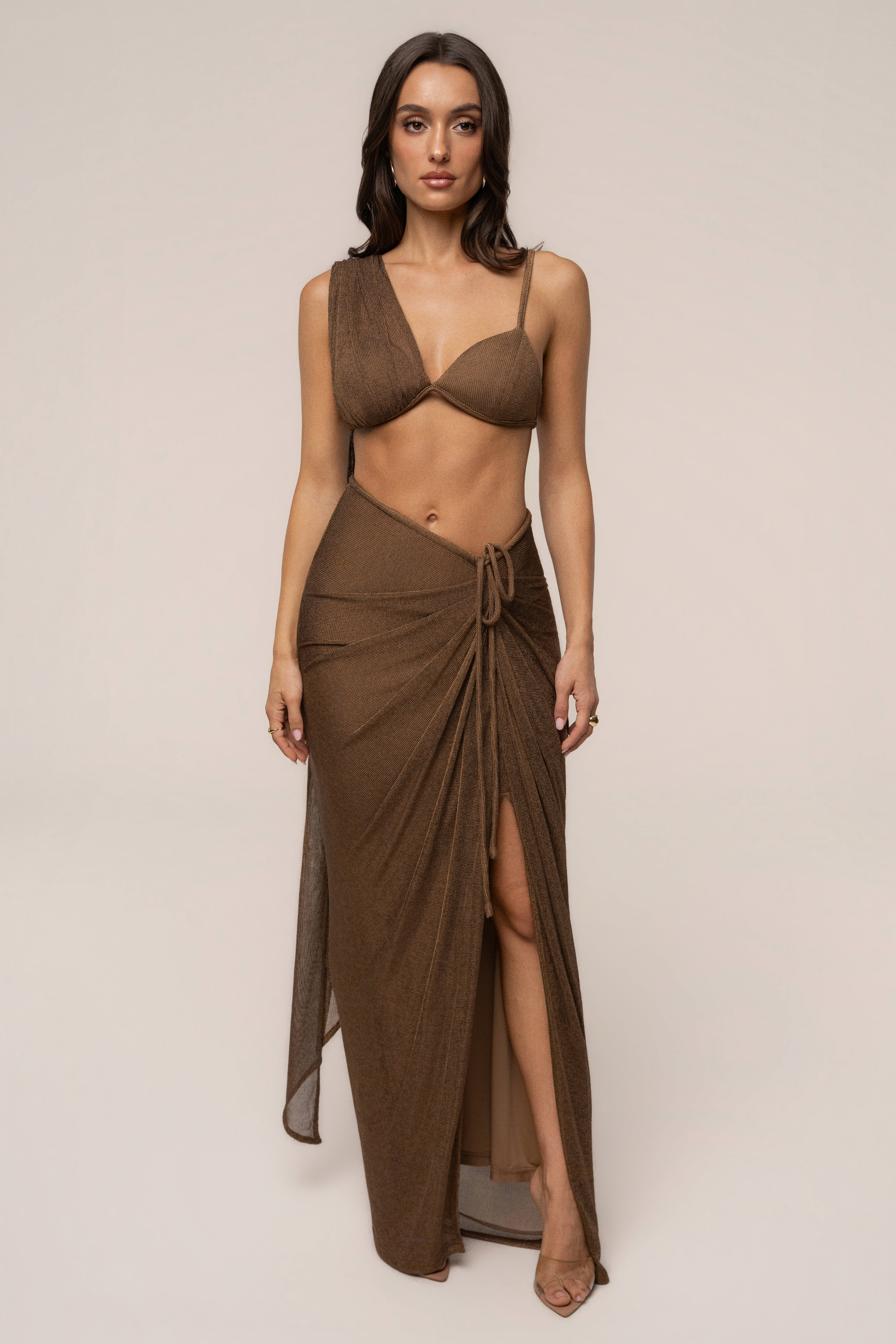 Bronze Noelia metallic slit skirt by JLUXLABEL featuring a shiny fabric, high waist, and side slit for a stylish, elegant look.