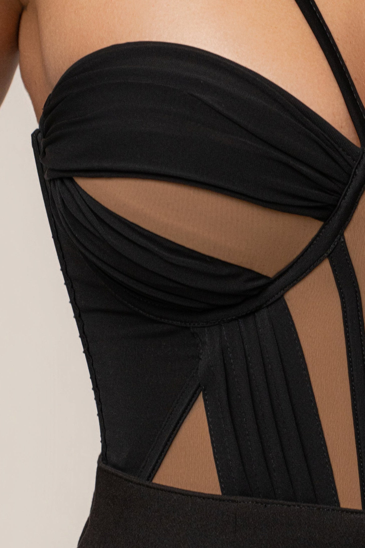 Black illusion contrast bodysuit by JLUXLABEL featuring sheer and opaque panels, form-fitting design, and long sleeves.