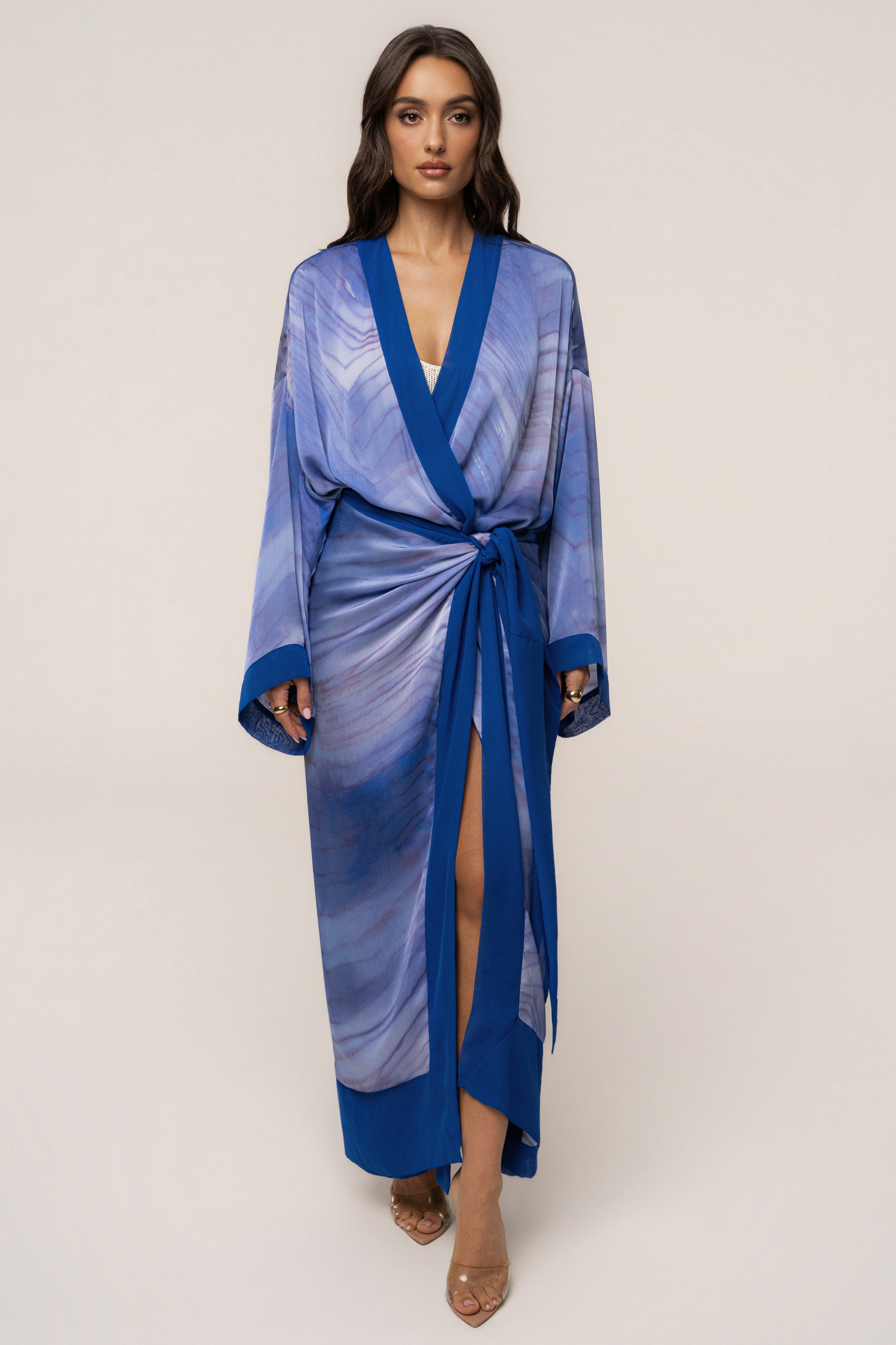 Blue Bahía satin duster outerwear by JLUXLABEL hanging on a rack with a soft, flowing fabric and elegant design.