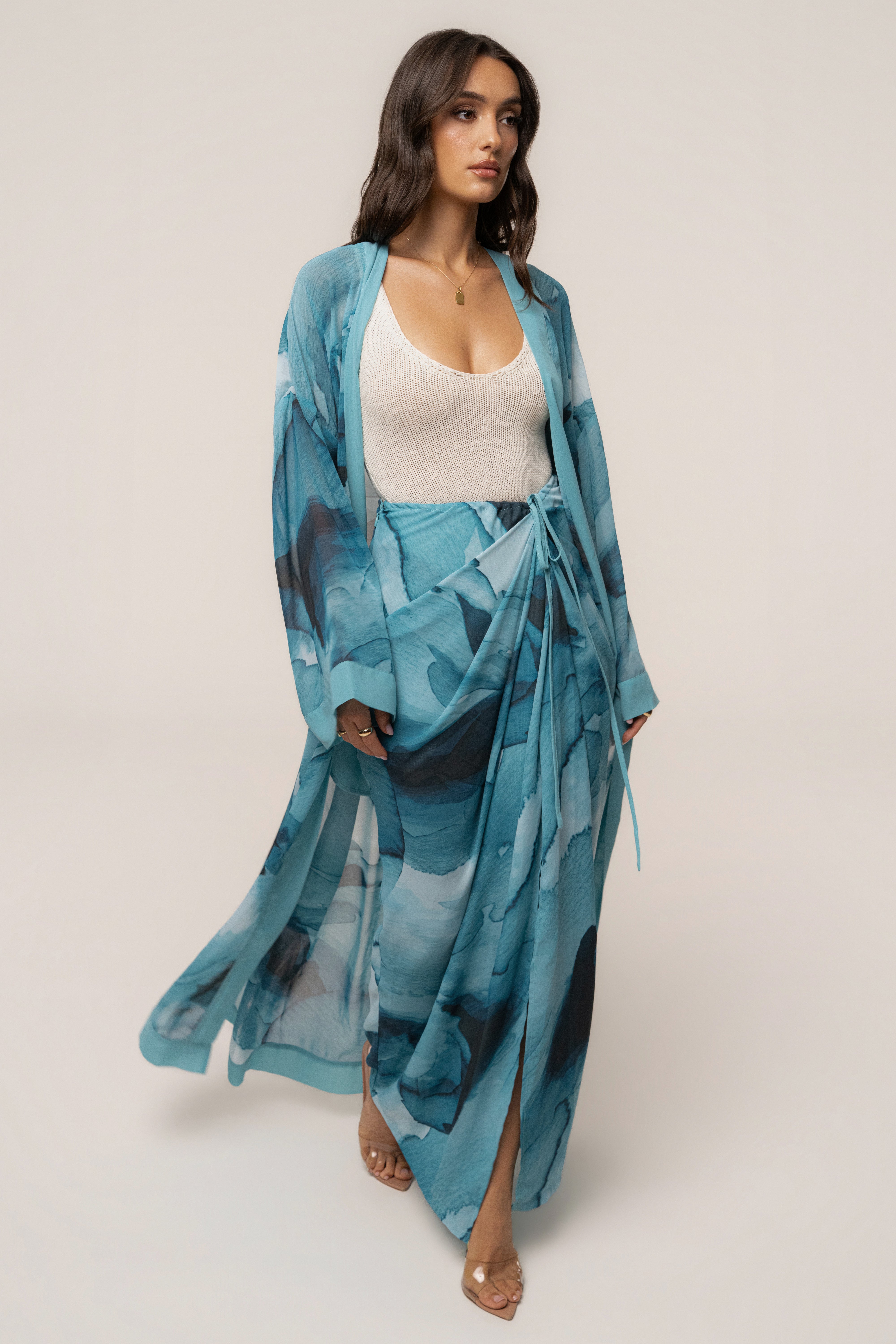 Blue abstract Alissa printed duster outerwear by JLUXLABEL, shown hanging with a flowy, lightweight fabric and vibrant abstract design.