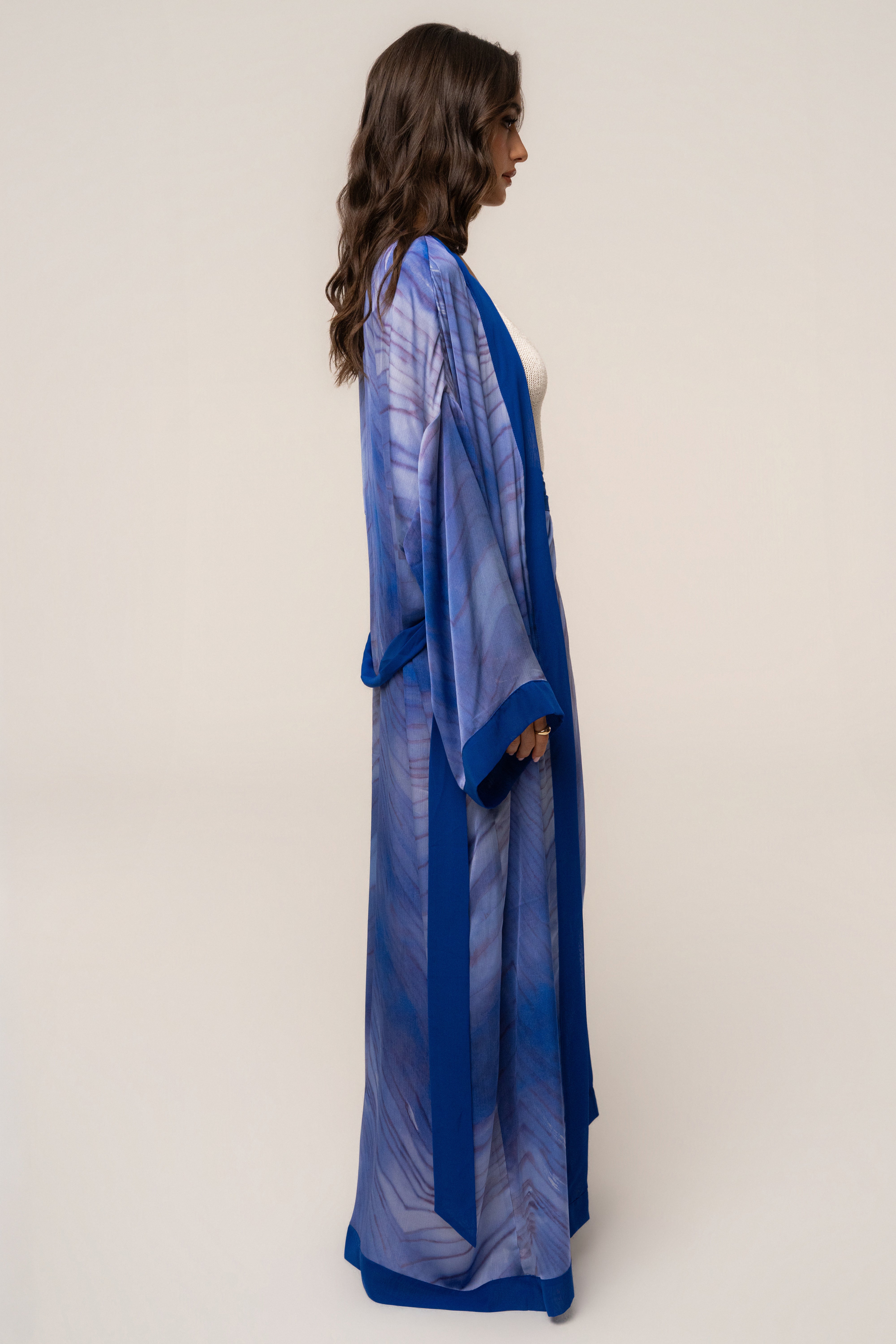Blue Bahía satin duster outerwear by JLUXLABEL, shown hanging open with a sleek, smooth satin finish and flowing silhouette.